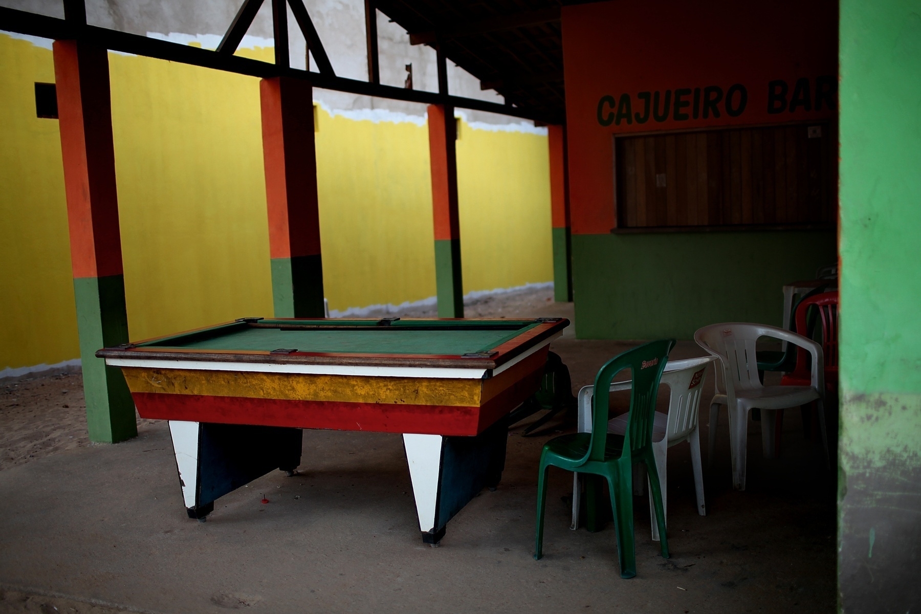 A colorful pool table sits in an empty bar.