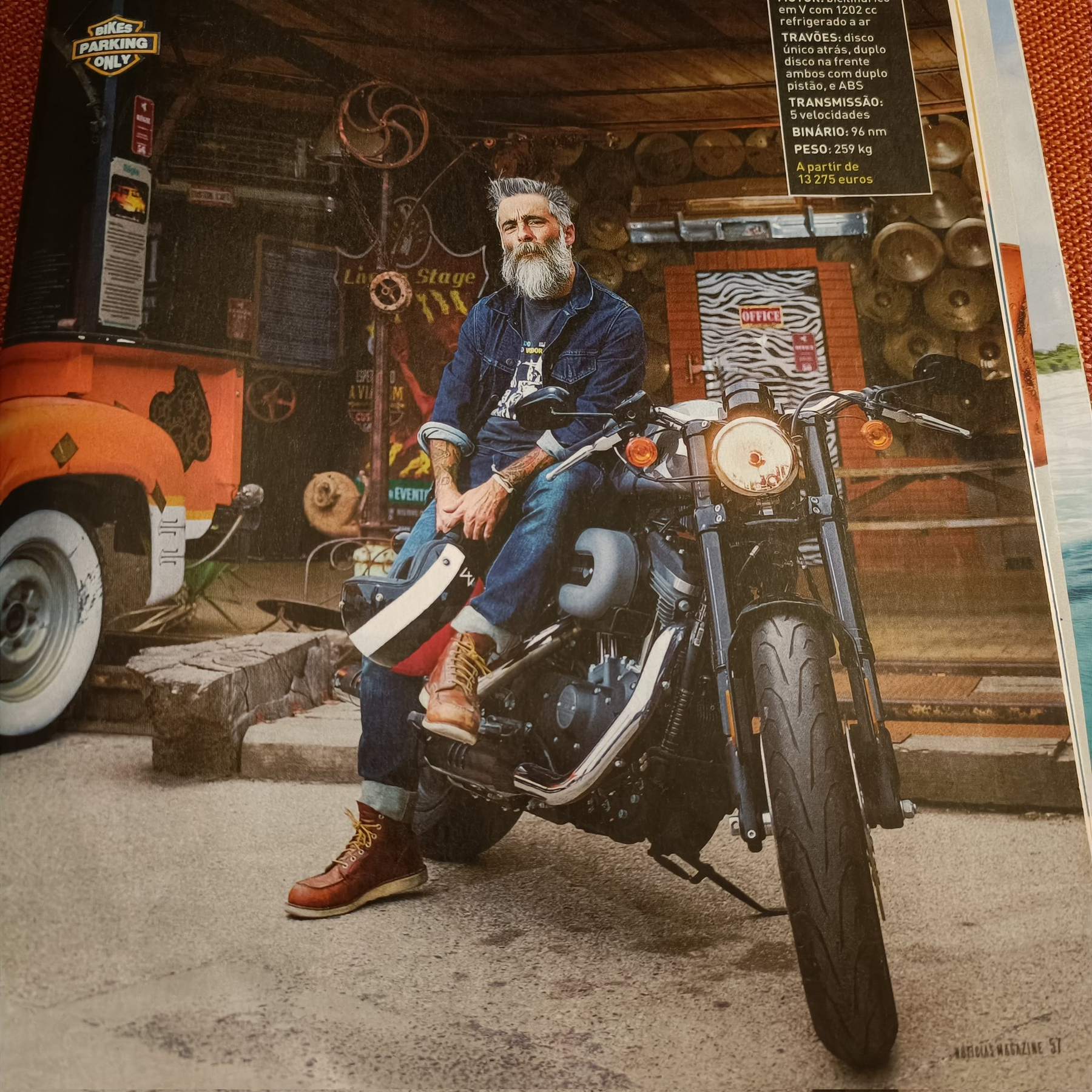 a man sits on a Harley motorcycle, in a magazine spread