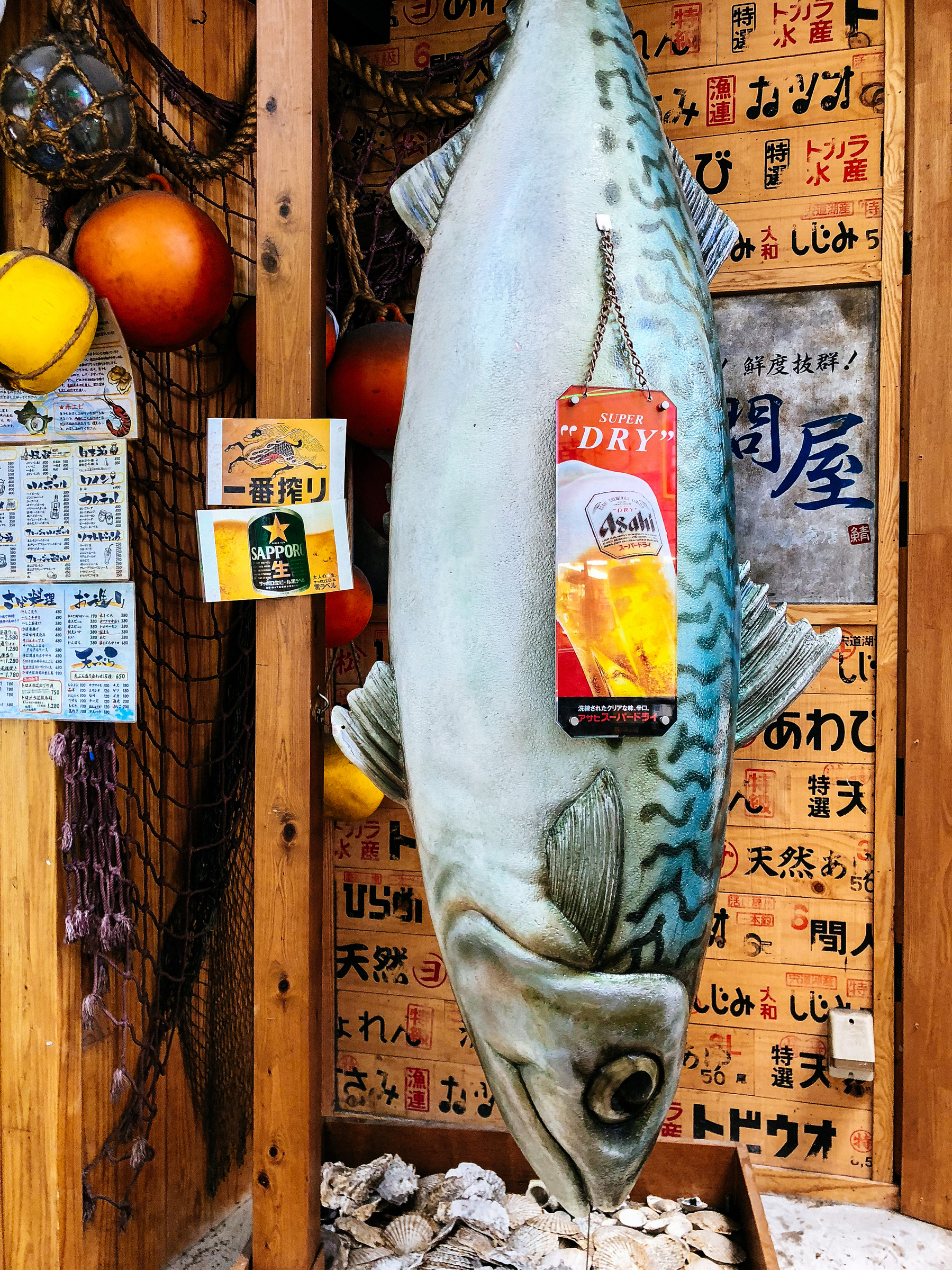 a big fake fish hangs outside a restaurant
