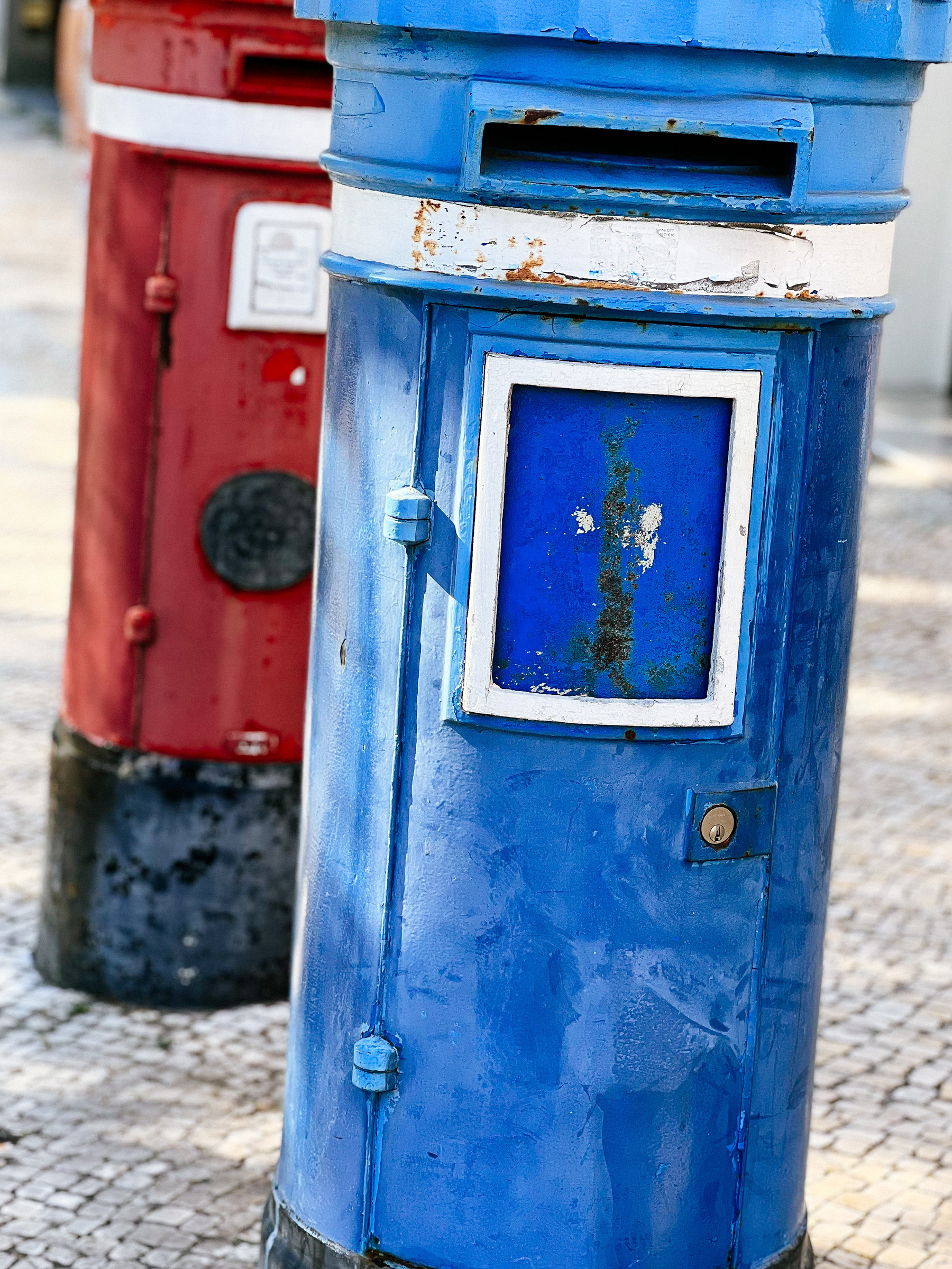 Mailboxes, one blue, one red. 