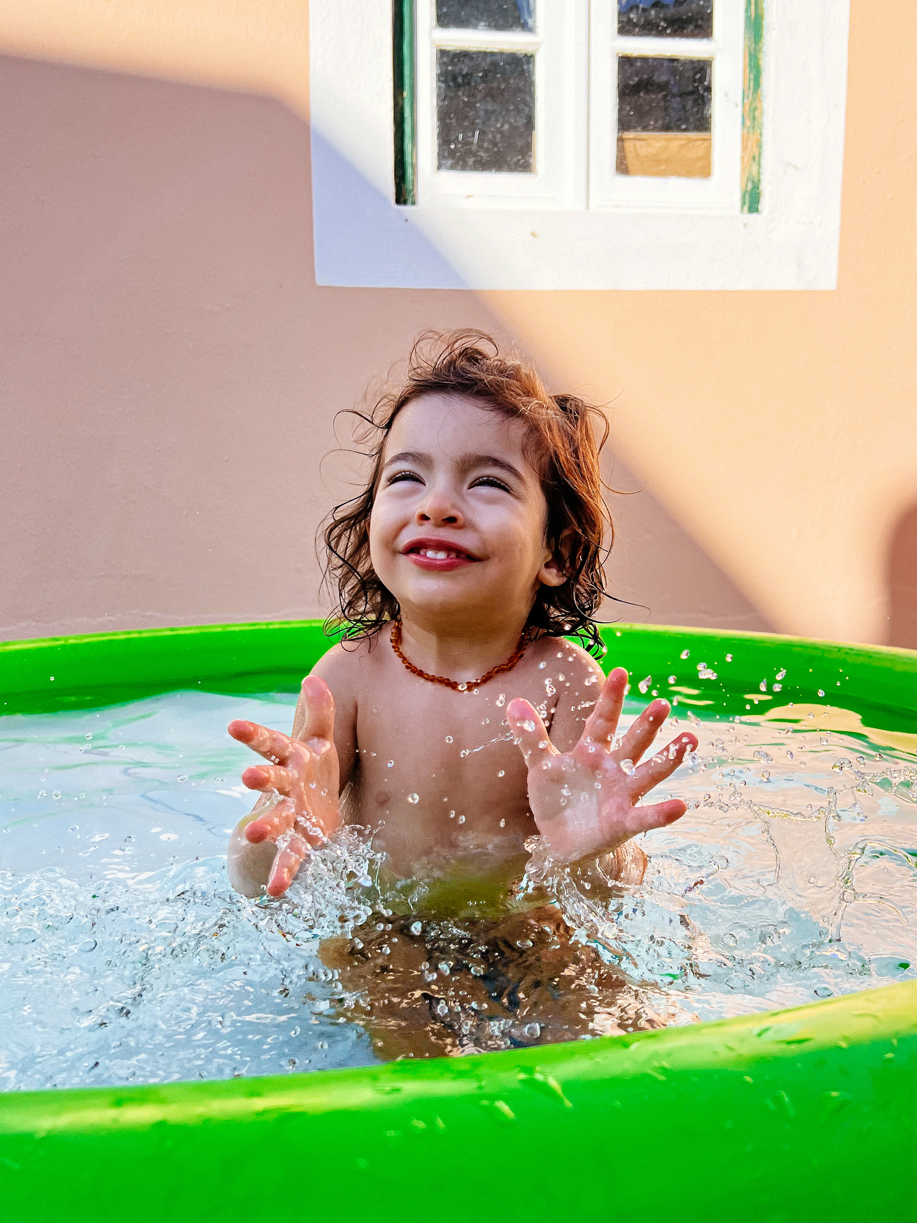 toddler laughs in a small pool