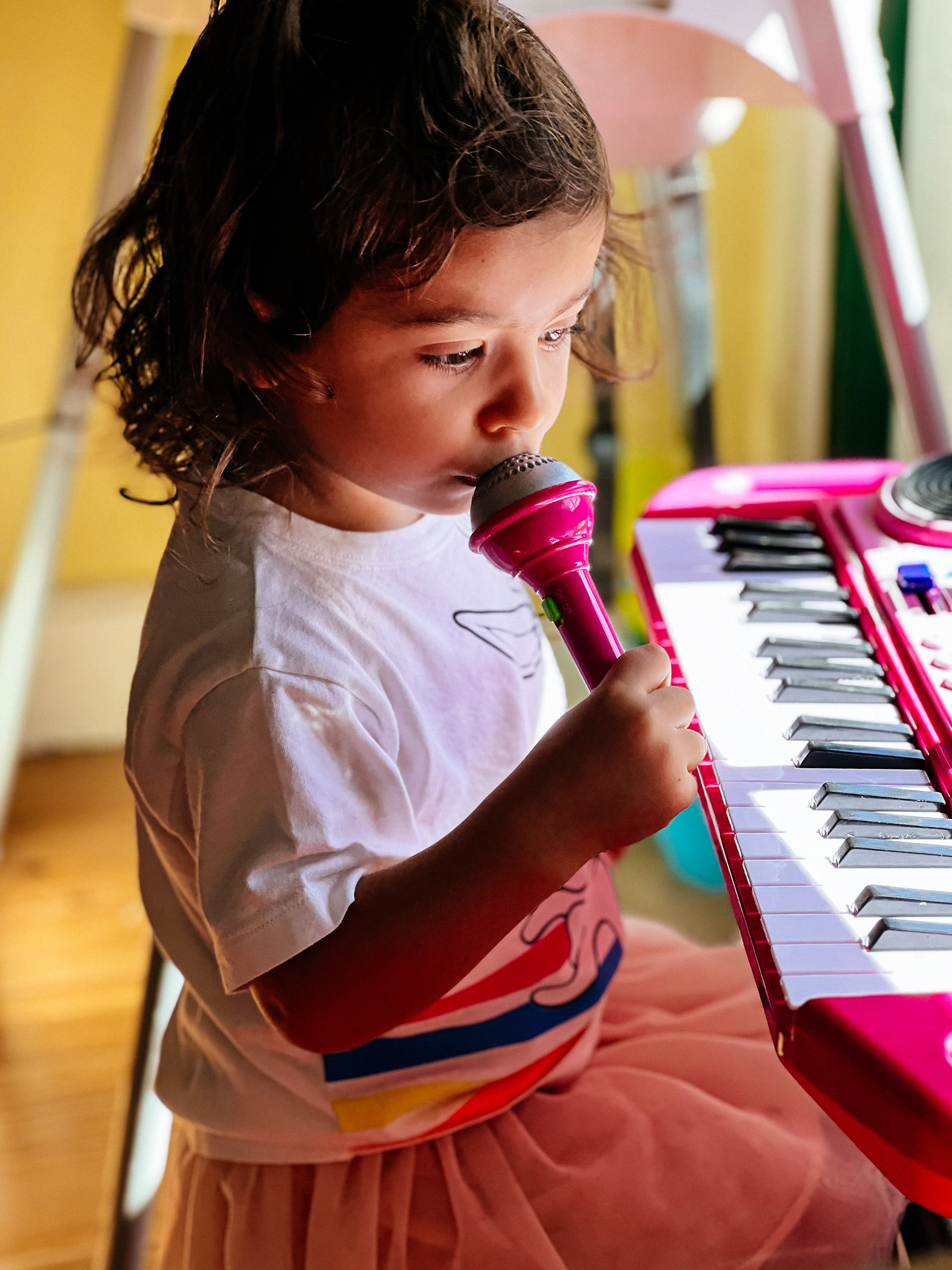 a toddler plays with a keyboard and mic set
