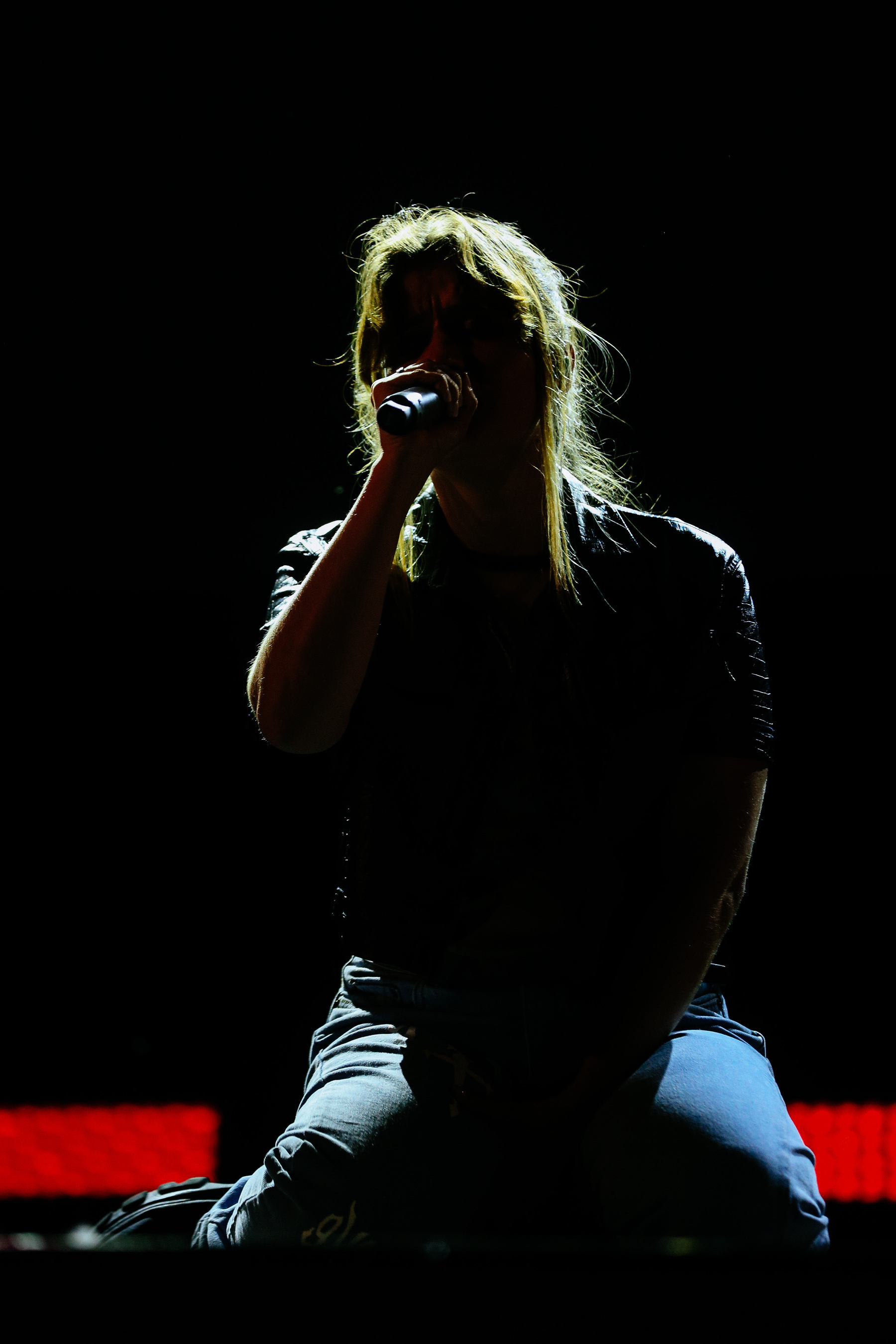 A singer kneeling on stage 