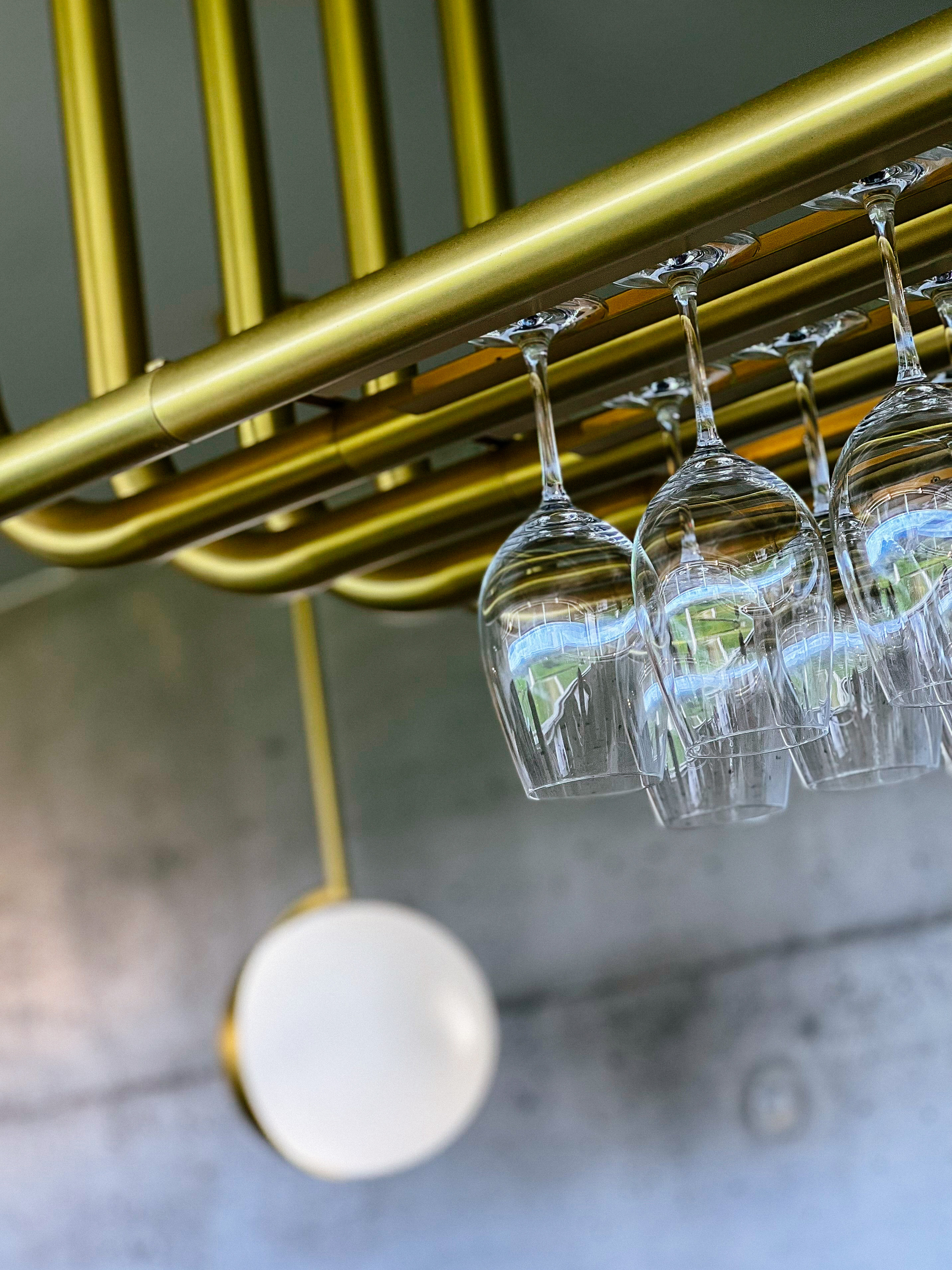 wine glasses hanging from a glass holder on the ceiling