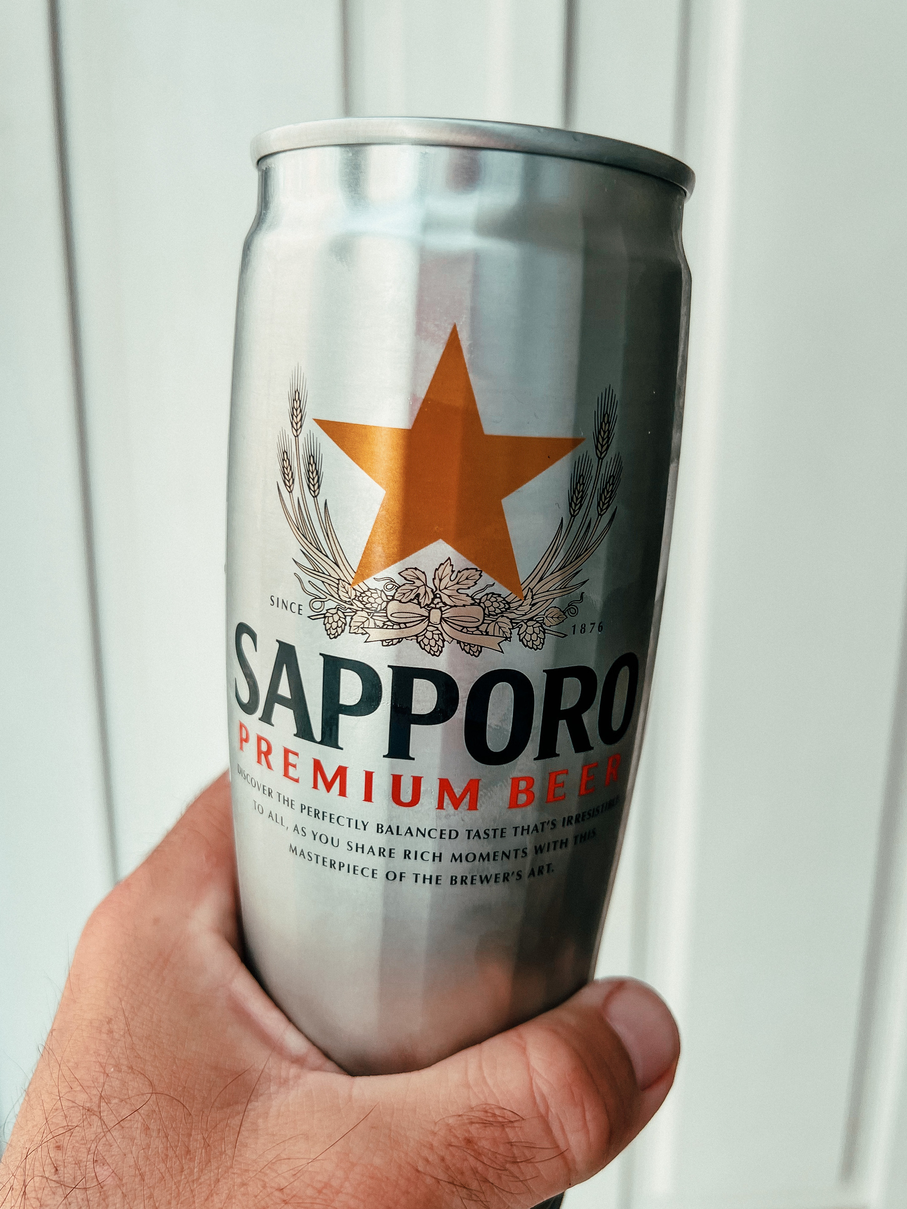 Hand holding a can of Sapporo beer. Yummy.
