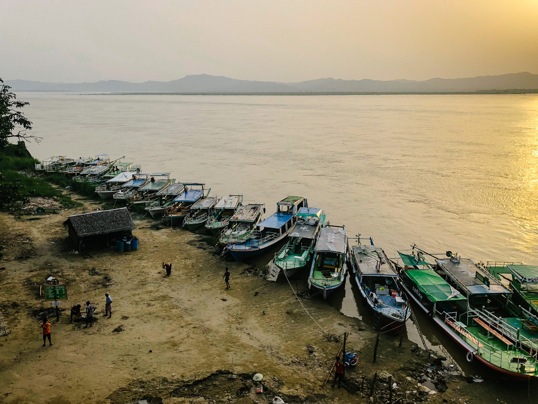 Boats parked on the bank of a wide river