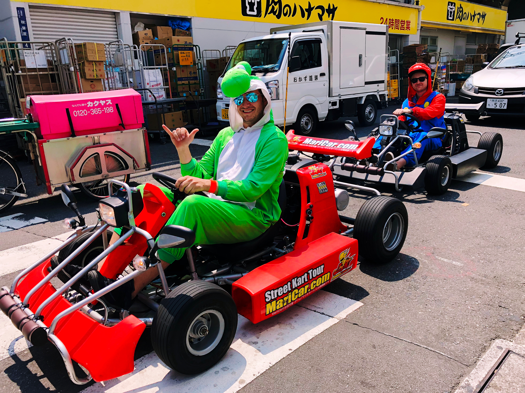 people dressed as Mario characters drive karts