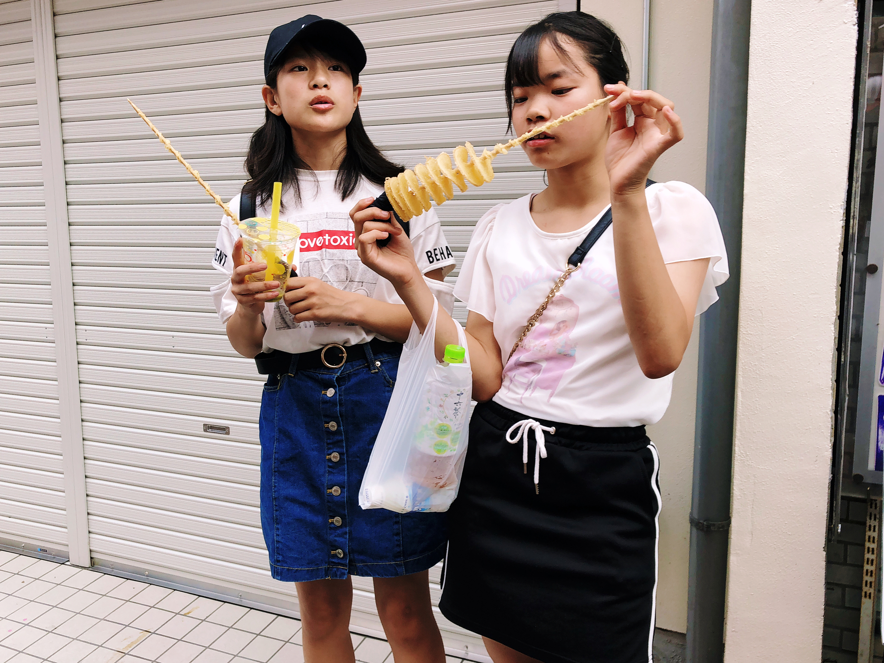Teenagers eating something from a stick