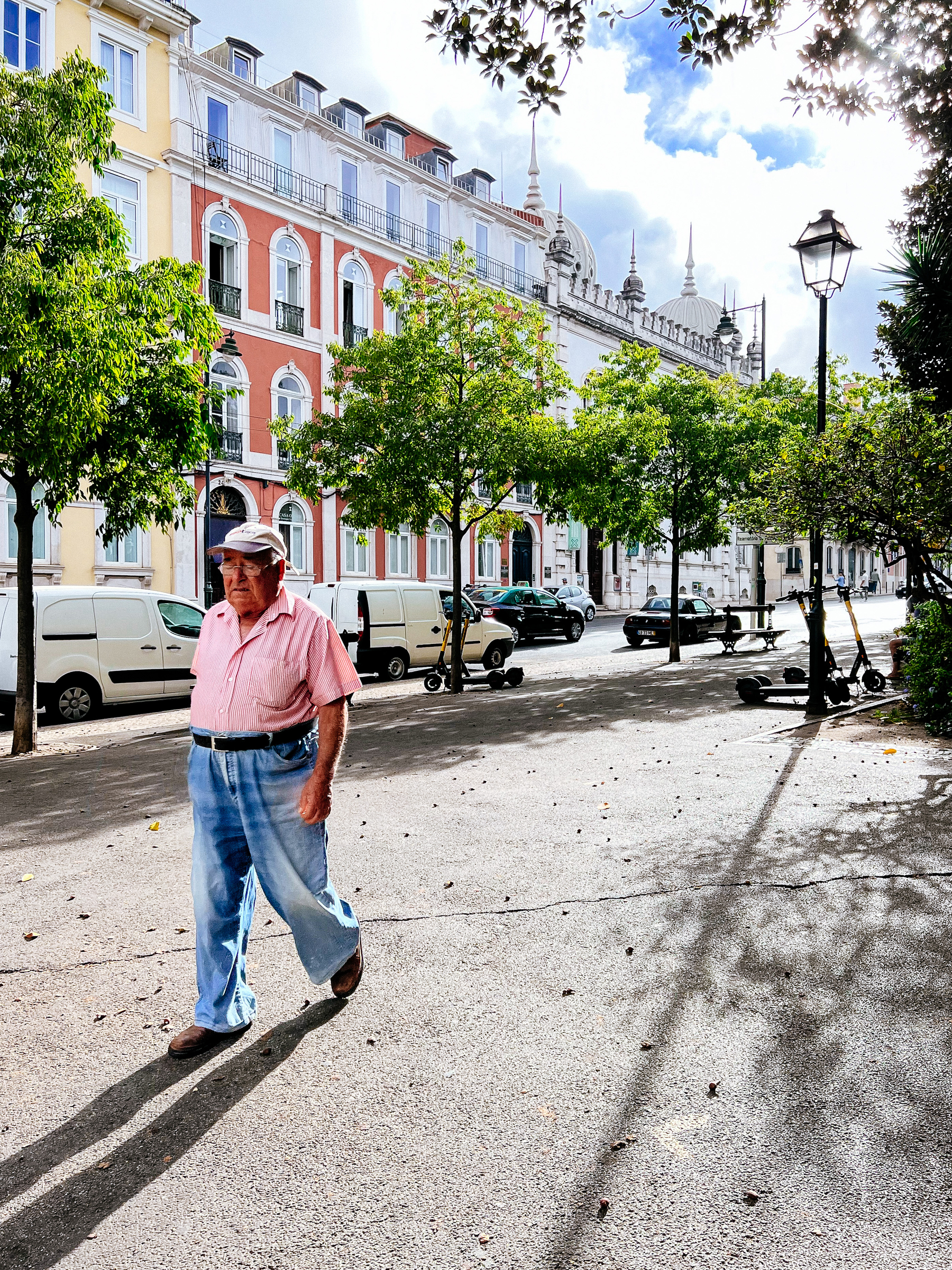 a man walks on the street, colorful buildings behind him