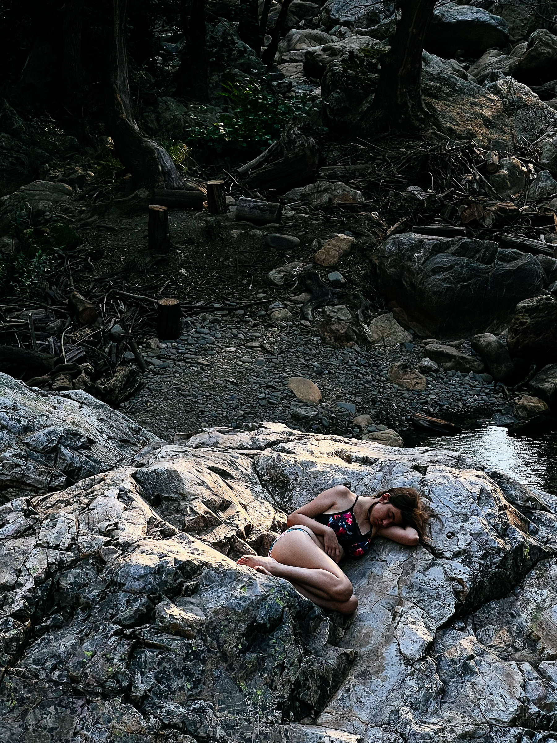 A girl sunbathing on a rock. 