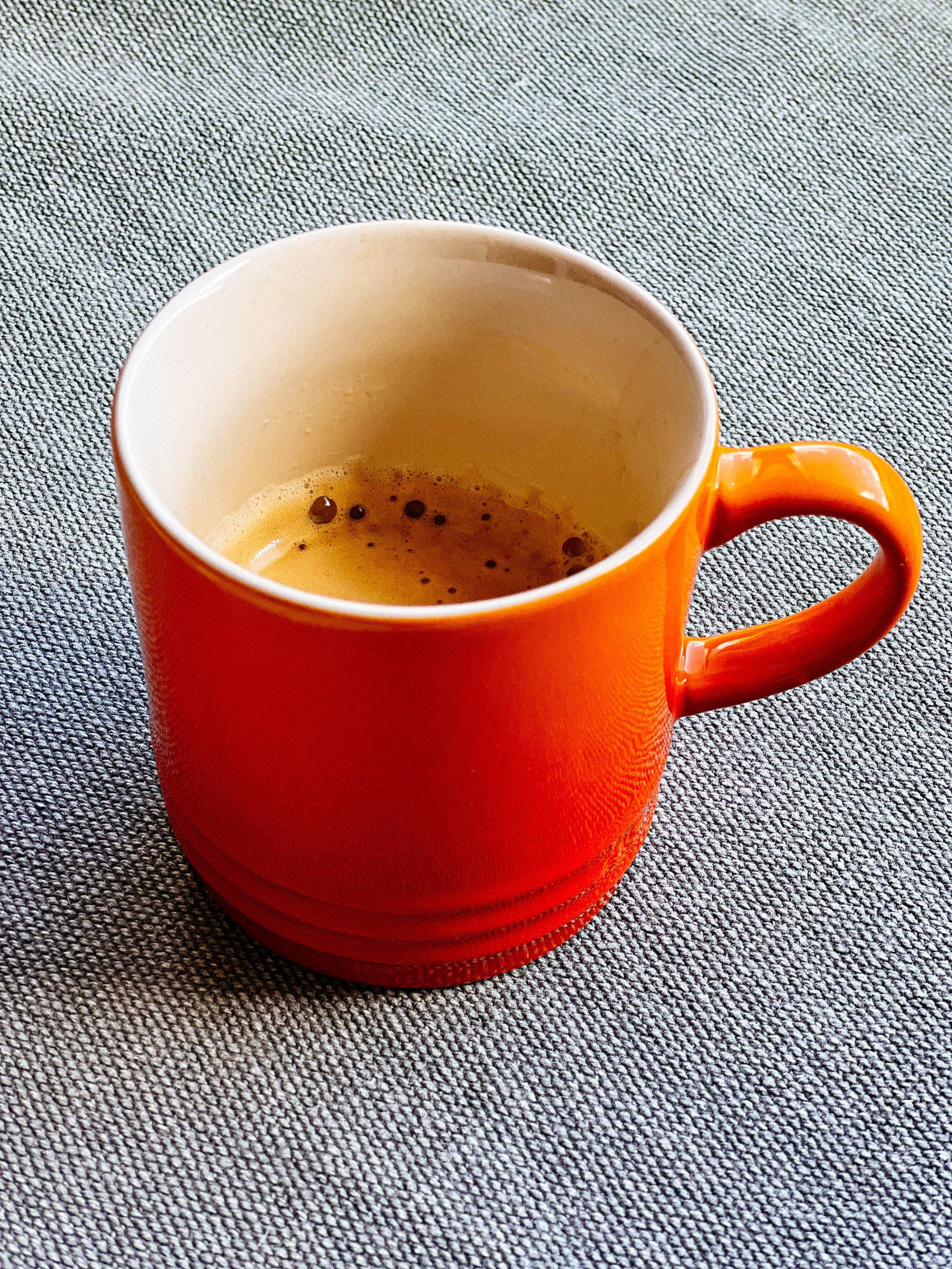 A big orange cup of coffee. 