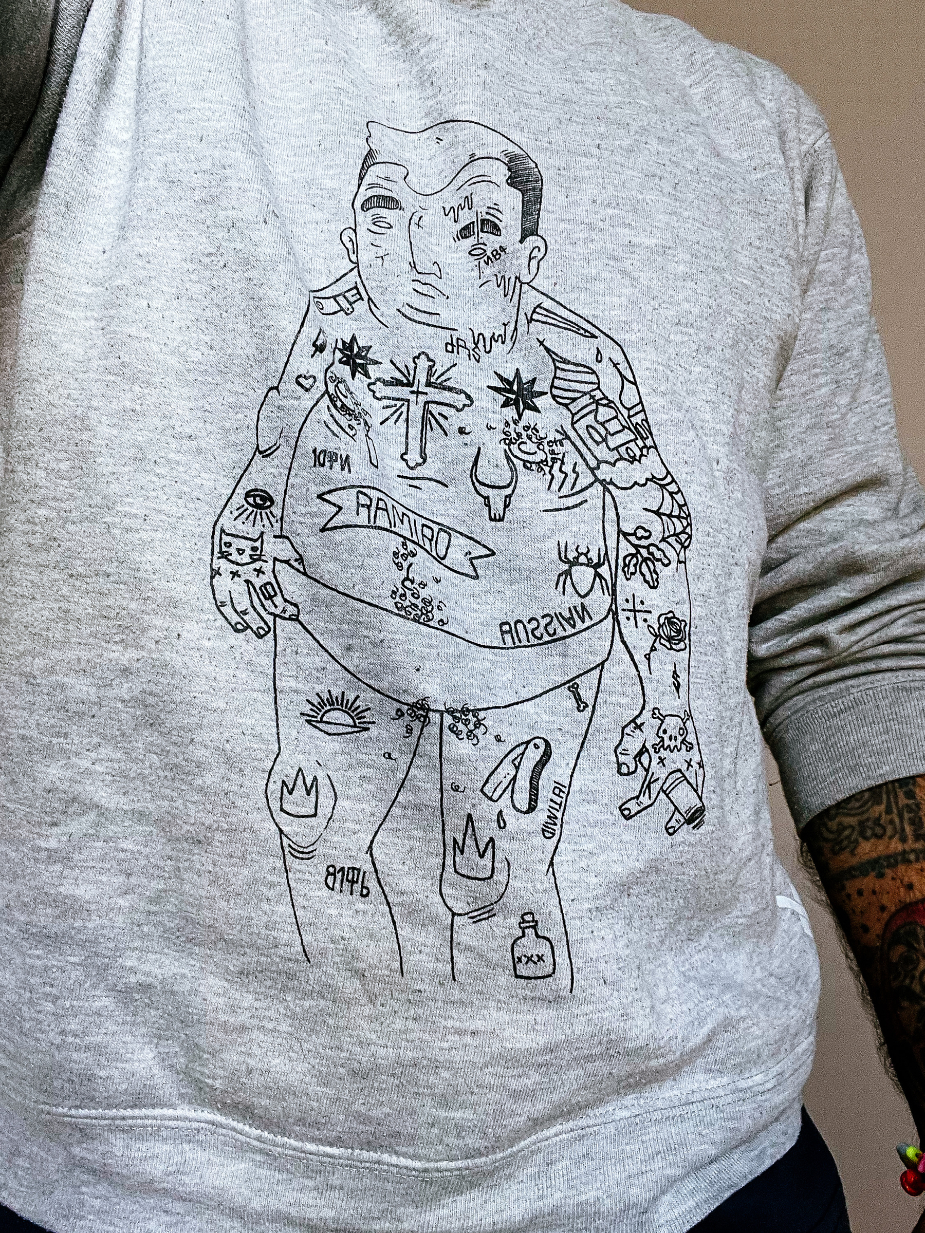 A sweatshirt with the drawing of a tattooed man in the front. 
