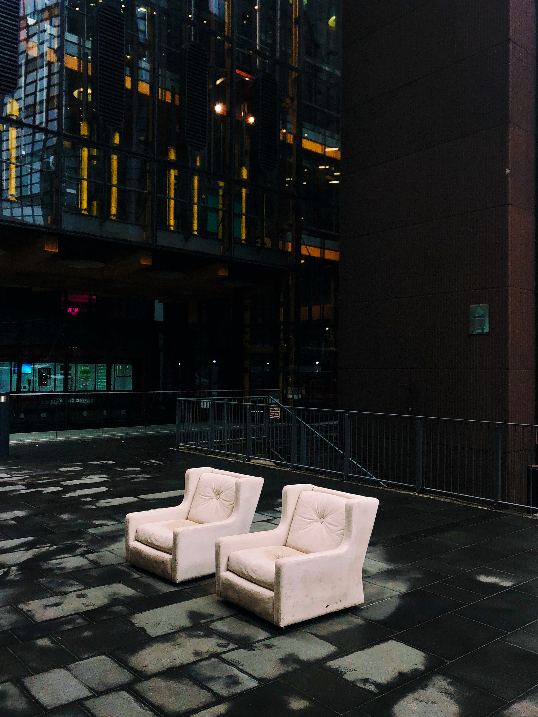 Two sofas side by side, seemingly abandoned in the middle of the central business district. 