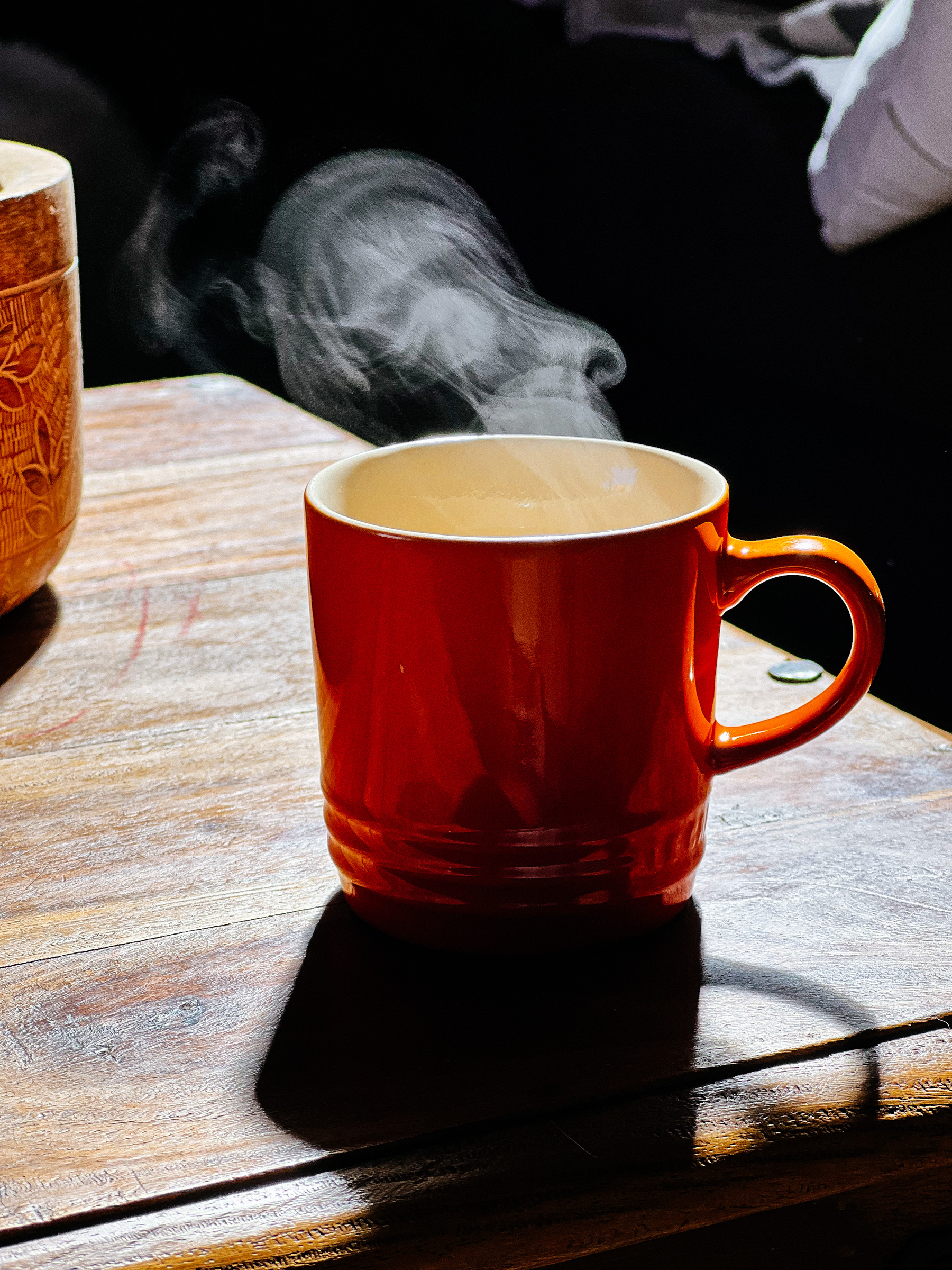 an orange tea cup, smoke coming out the top