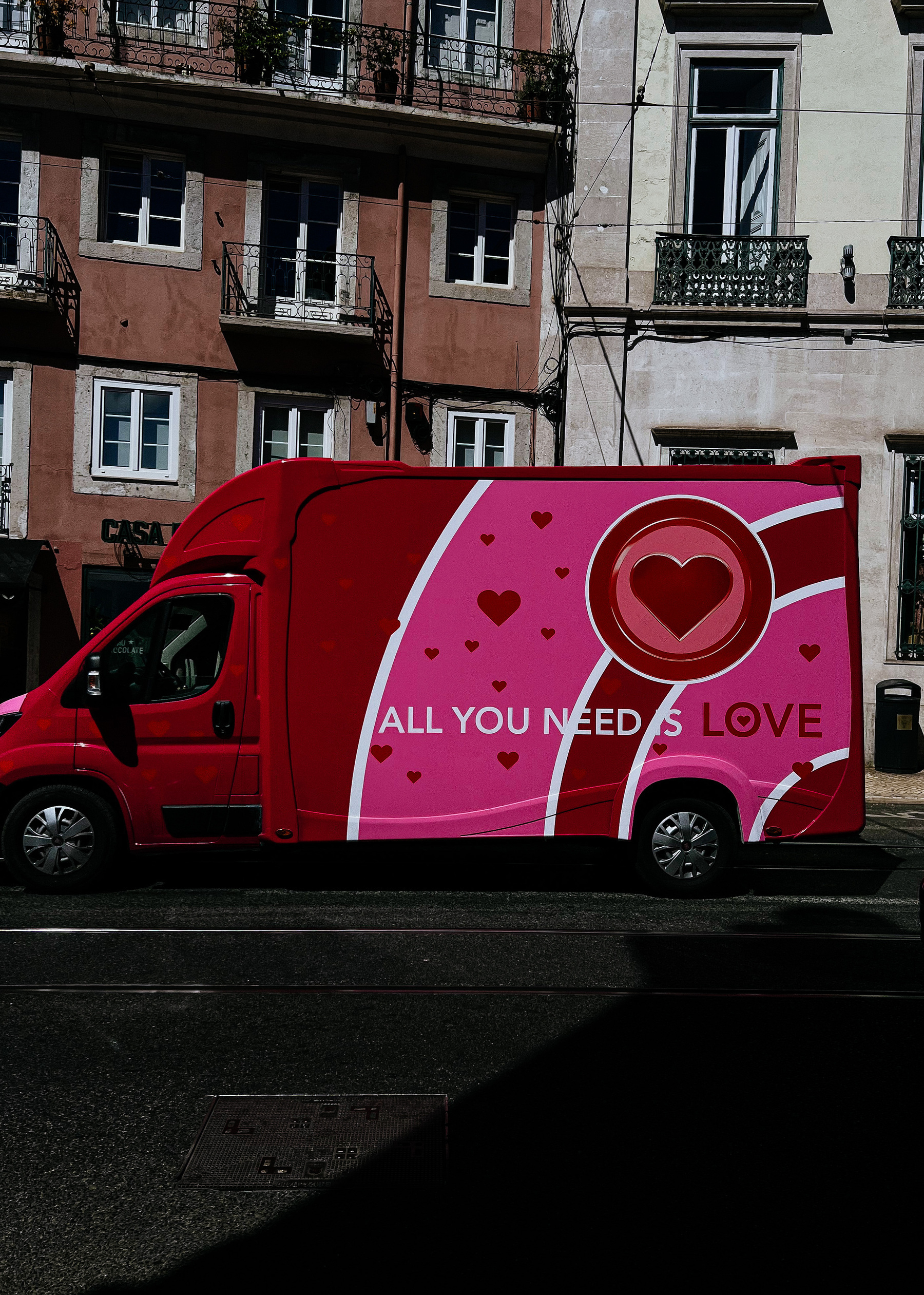 A truck painted in pink, with the words “All you need is love” on it. 