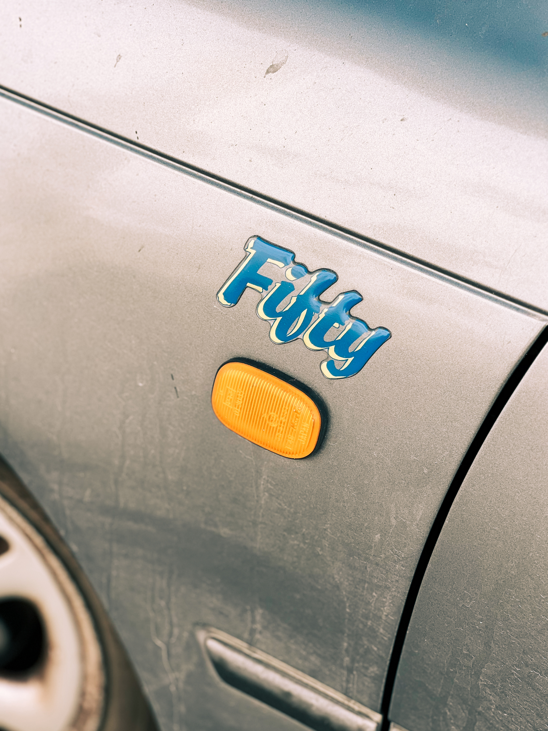 A “Fifty” sticker on a dirty car.