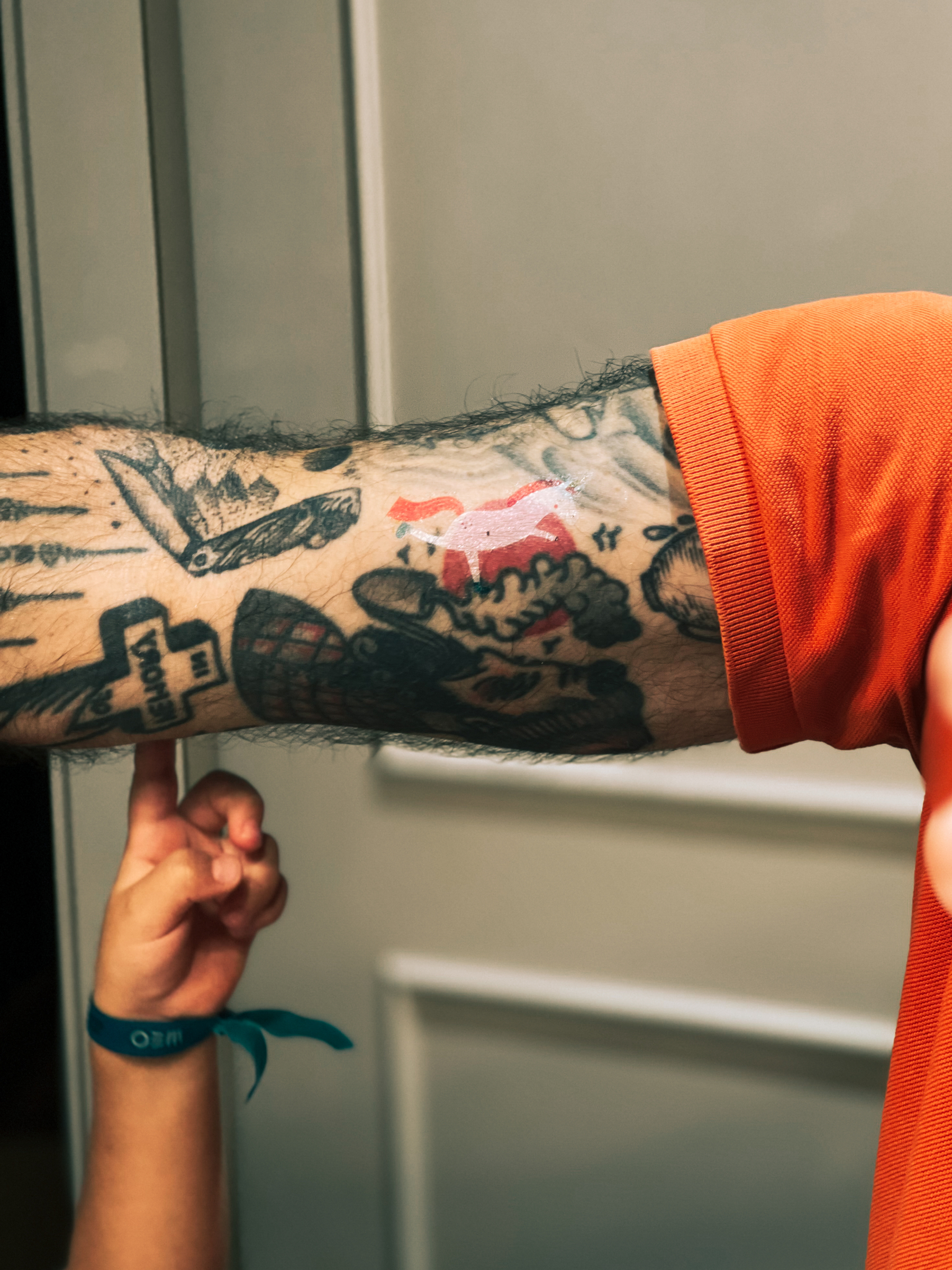 Tattooed arm with a fake unicorn tattoo. 