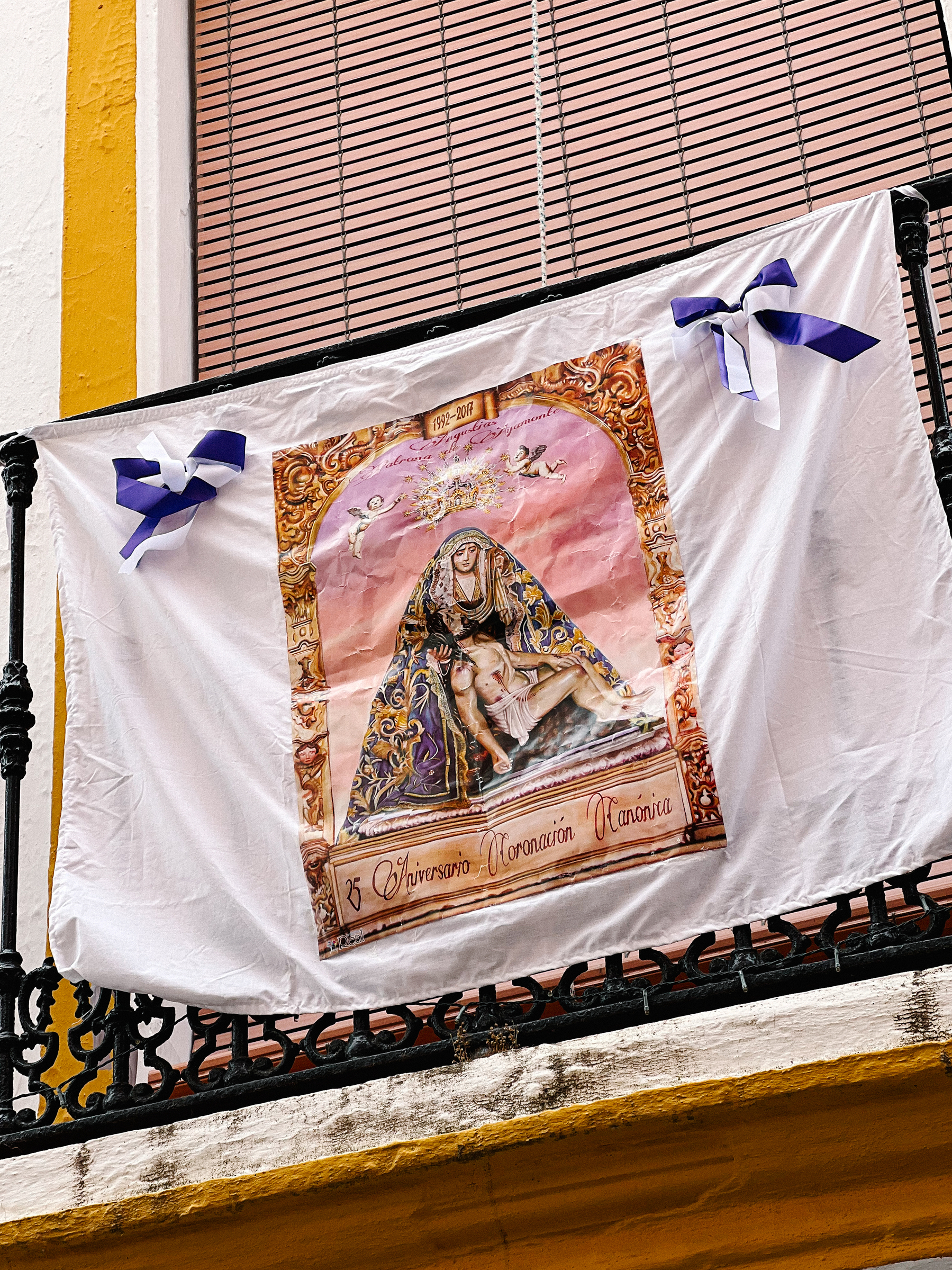 A religious figure on a towel, hanging from a window. 