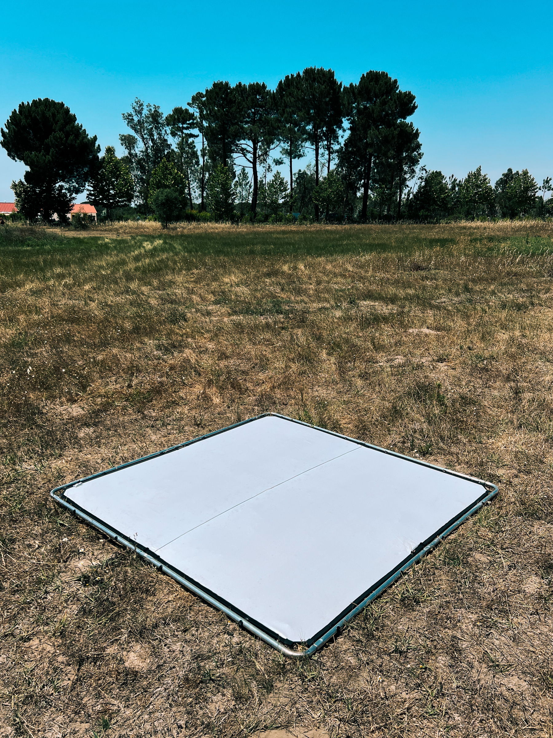 A reflector sits on the ground, in the middle of a field. 
