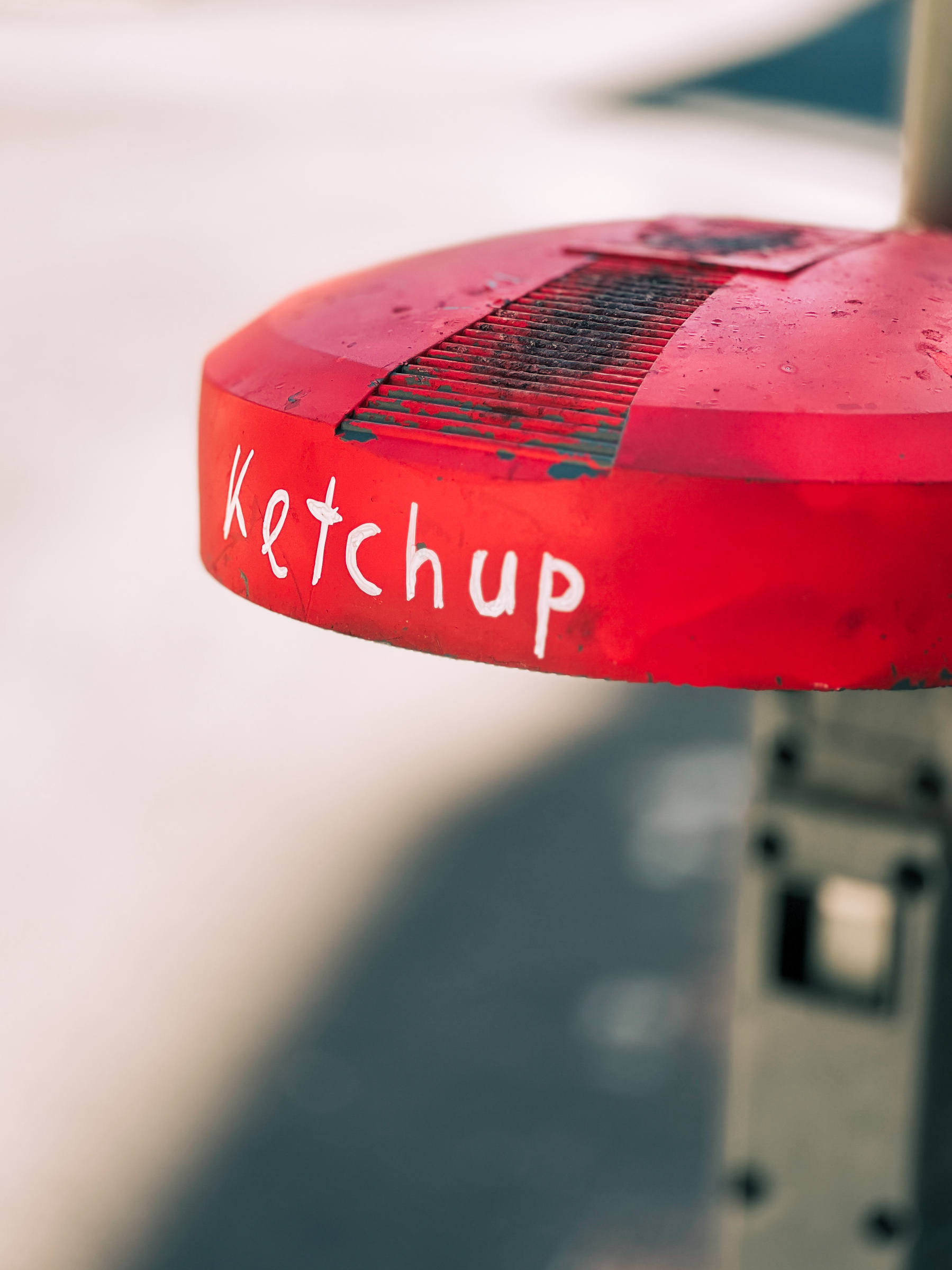 “Ketchup” written on a trash can cover. 