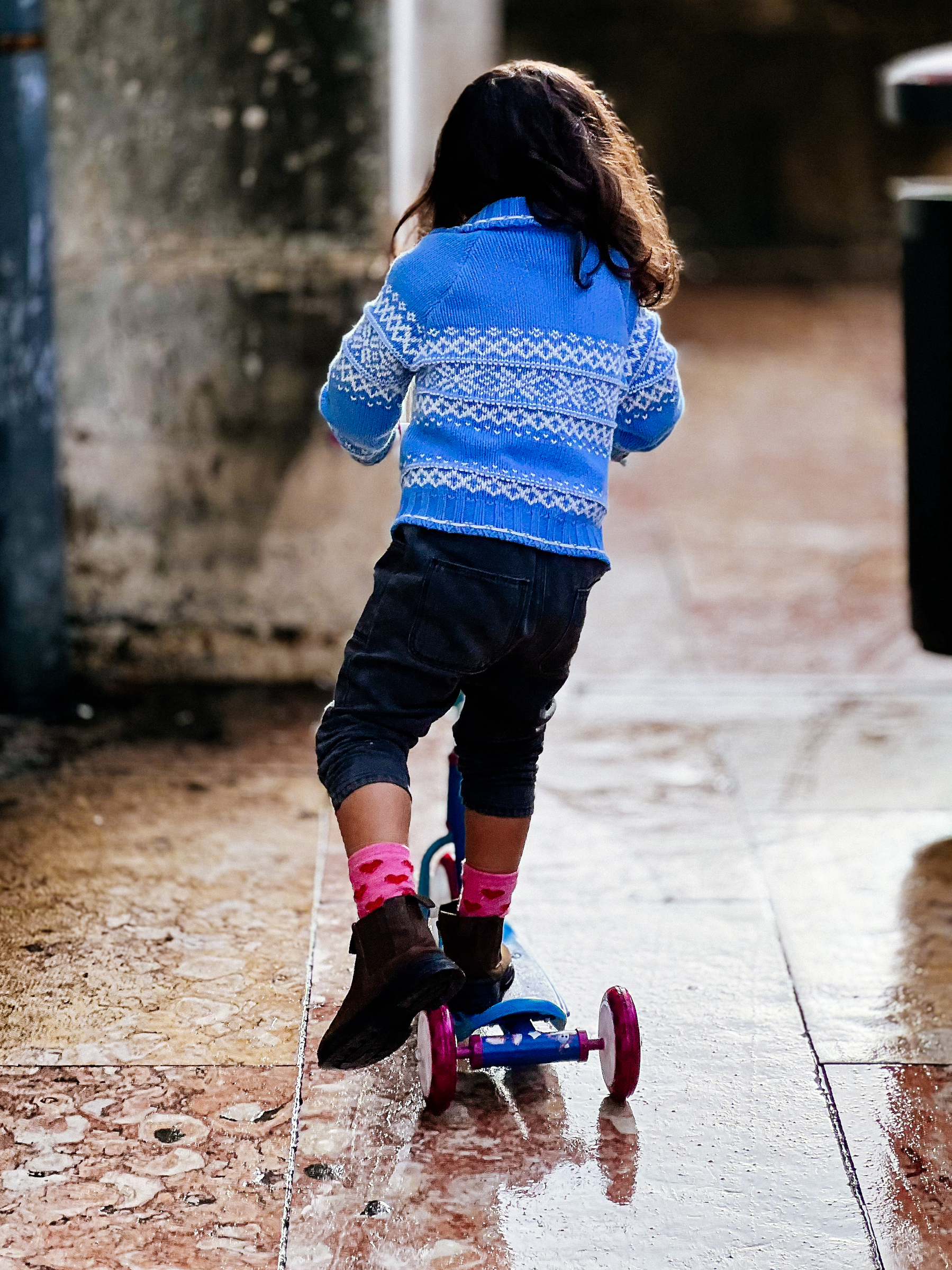 A girl riding a scooter.