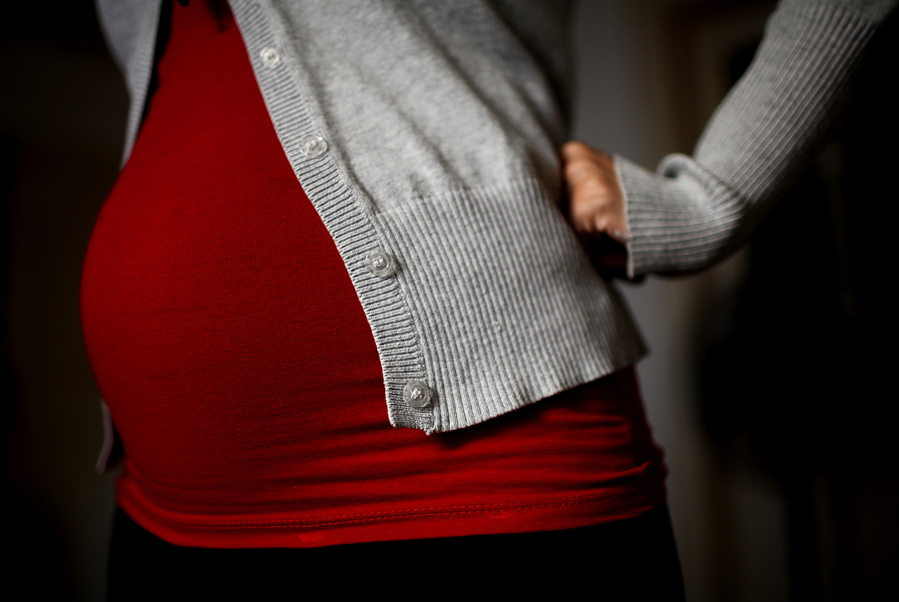 A pregnant woman with a red sweater.