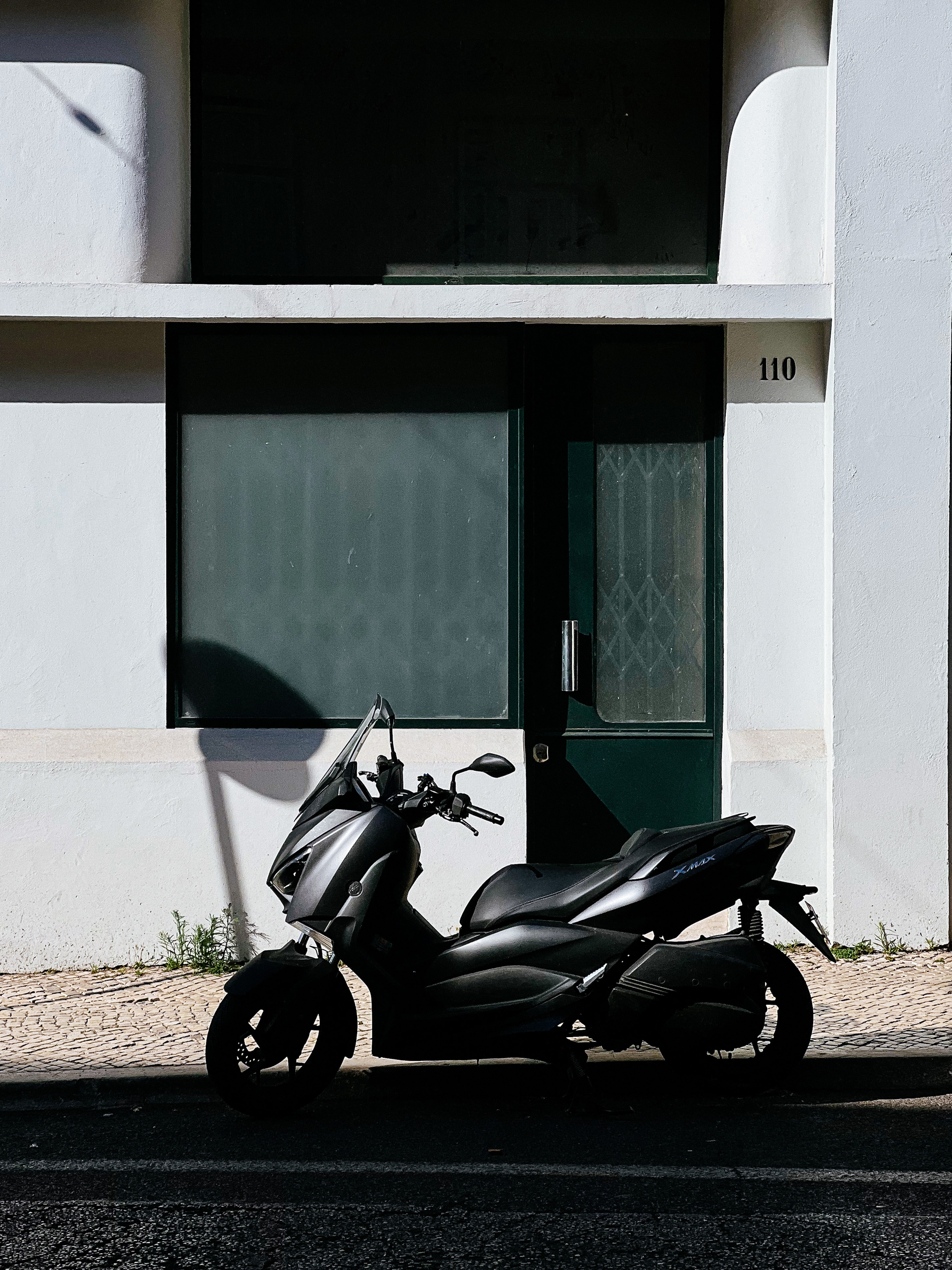 A scooter is parked in front of a building. 