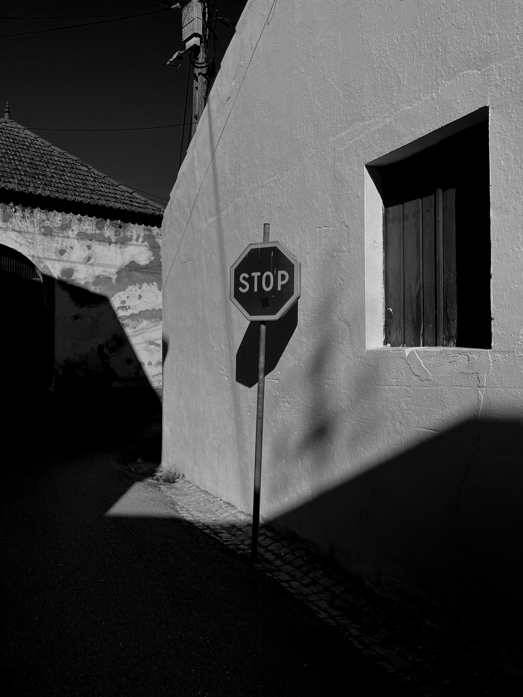 Black and white photo, a stop sign in a corner. 