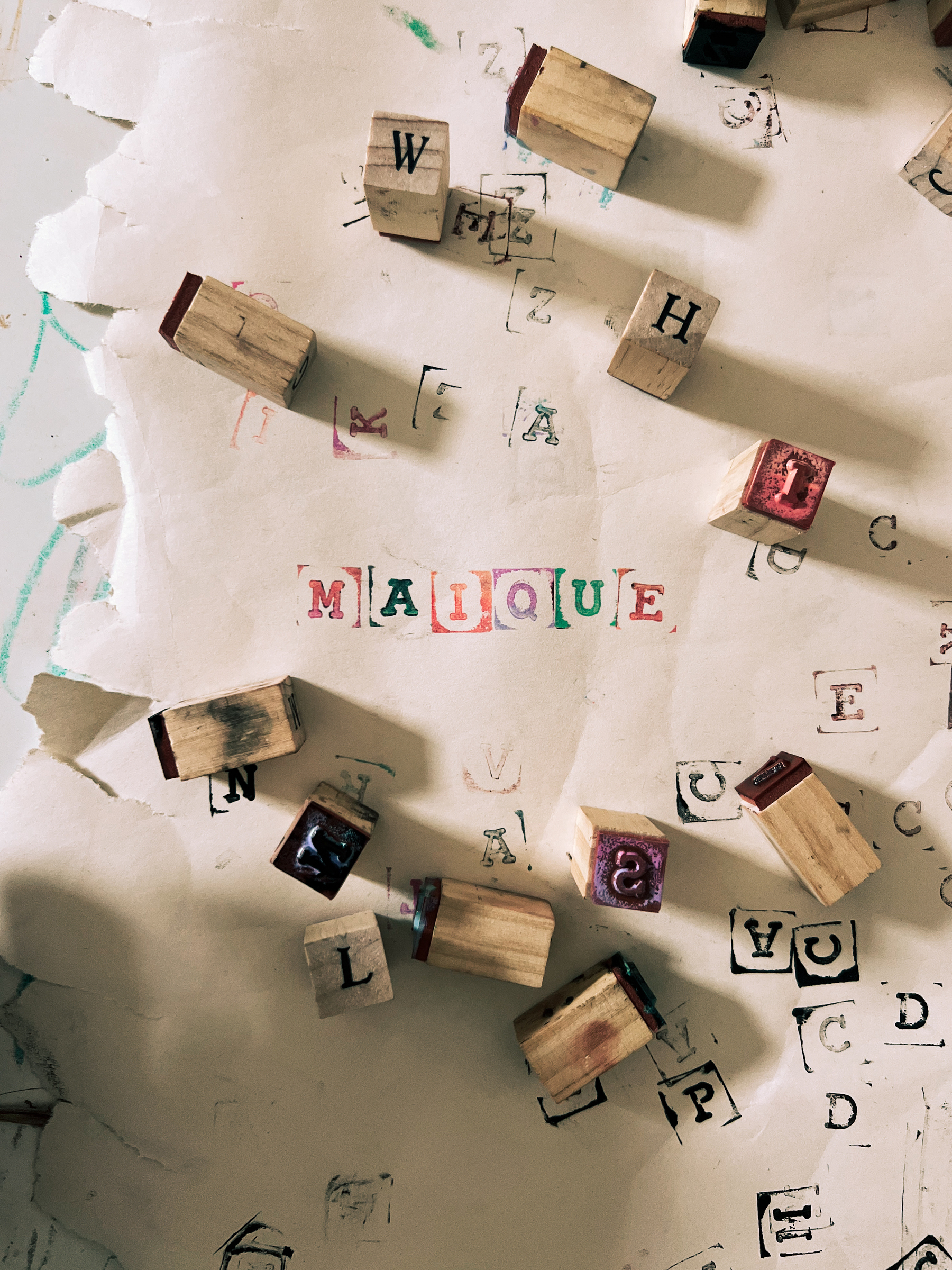 The word &ldquo;maique&rdquo; in individual letters, stamped on paper. Stamps are spread all over.