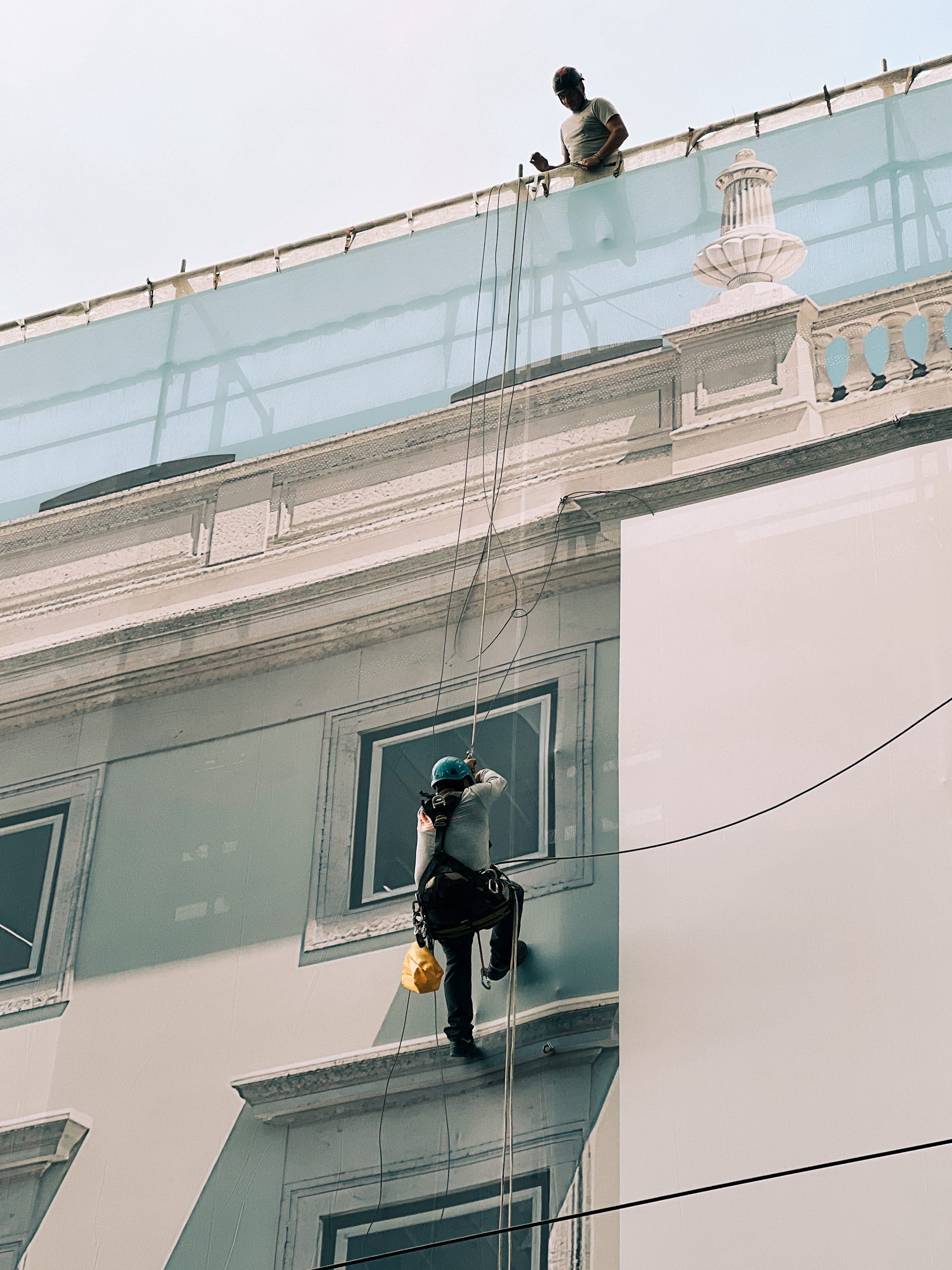 A man rappelling down a building. 
