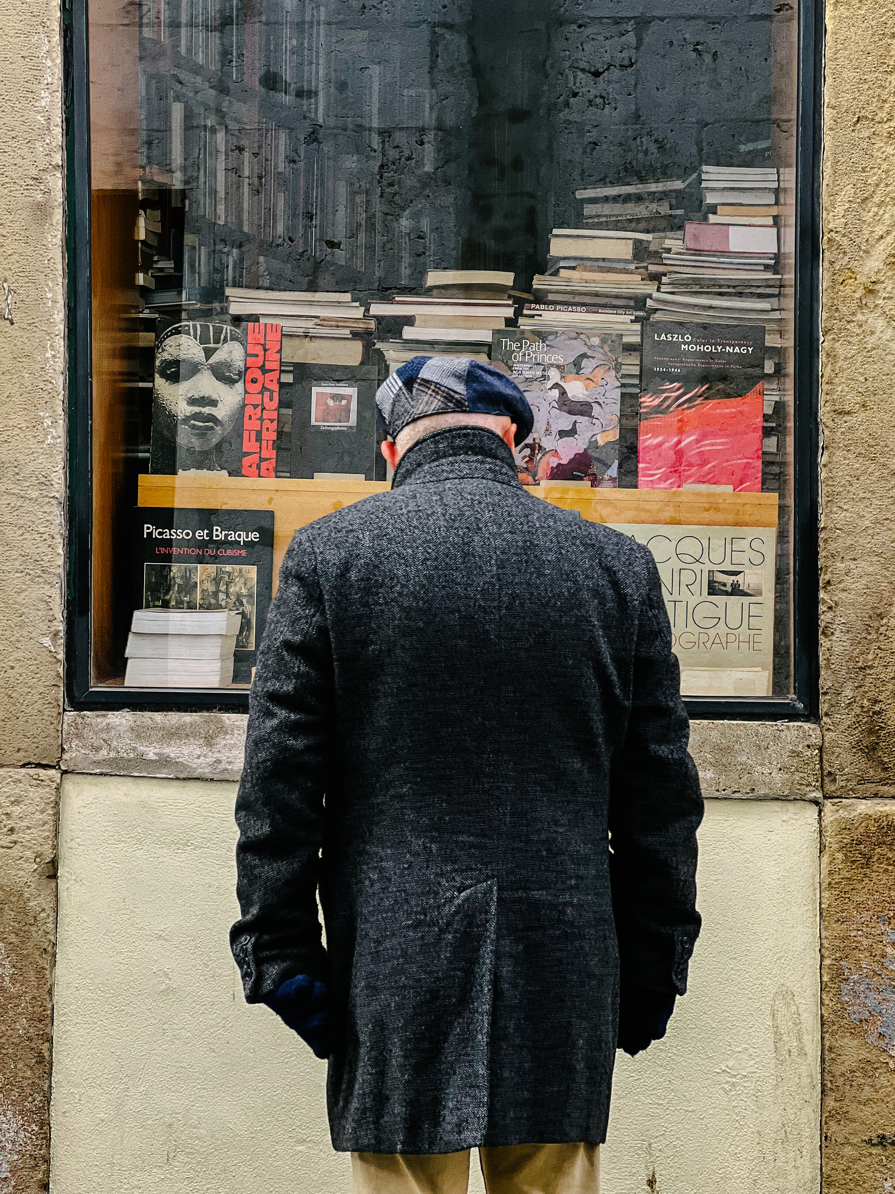 A man looks at a bookstore’s window. 