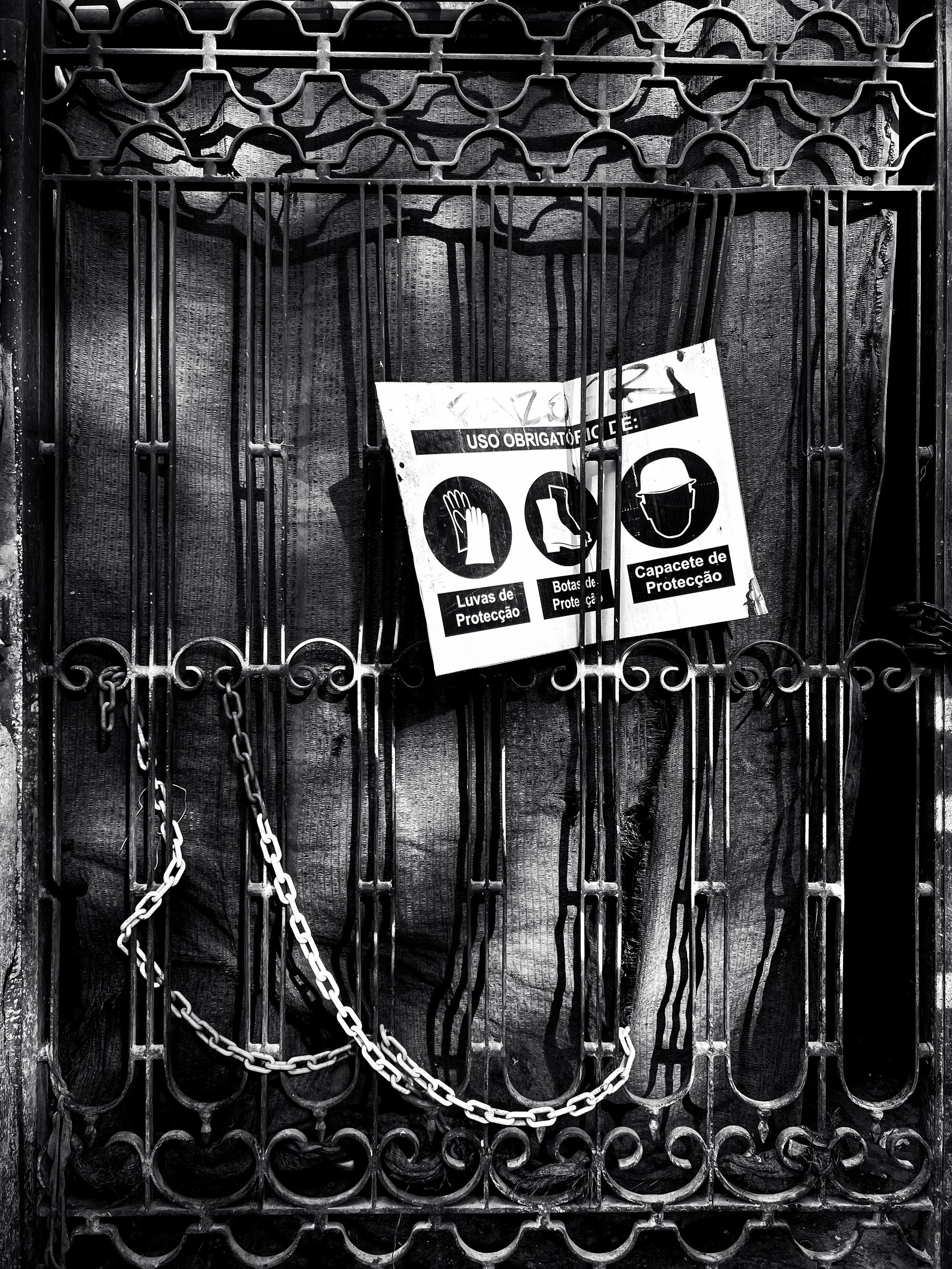Black and white photo, a chained door, and a construction safety card. 