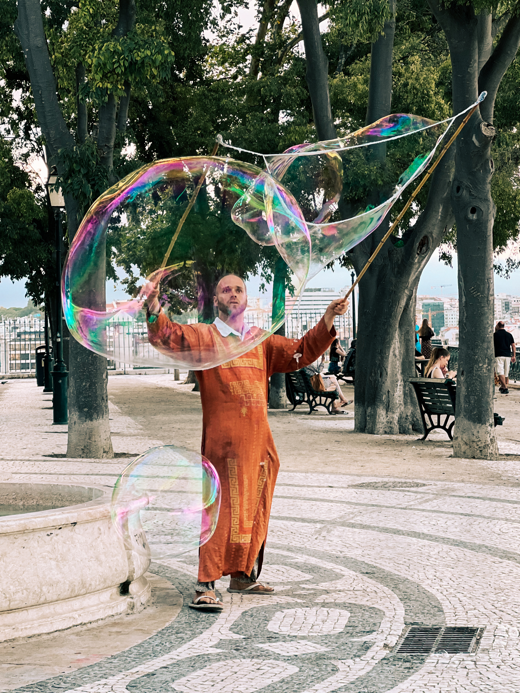 Street performer makes giant soap bubbles.￼