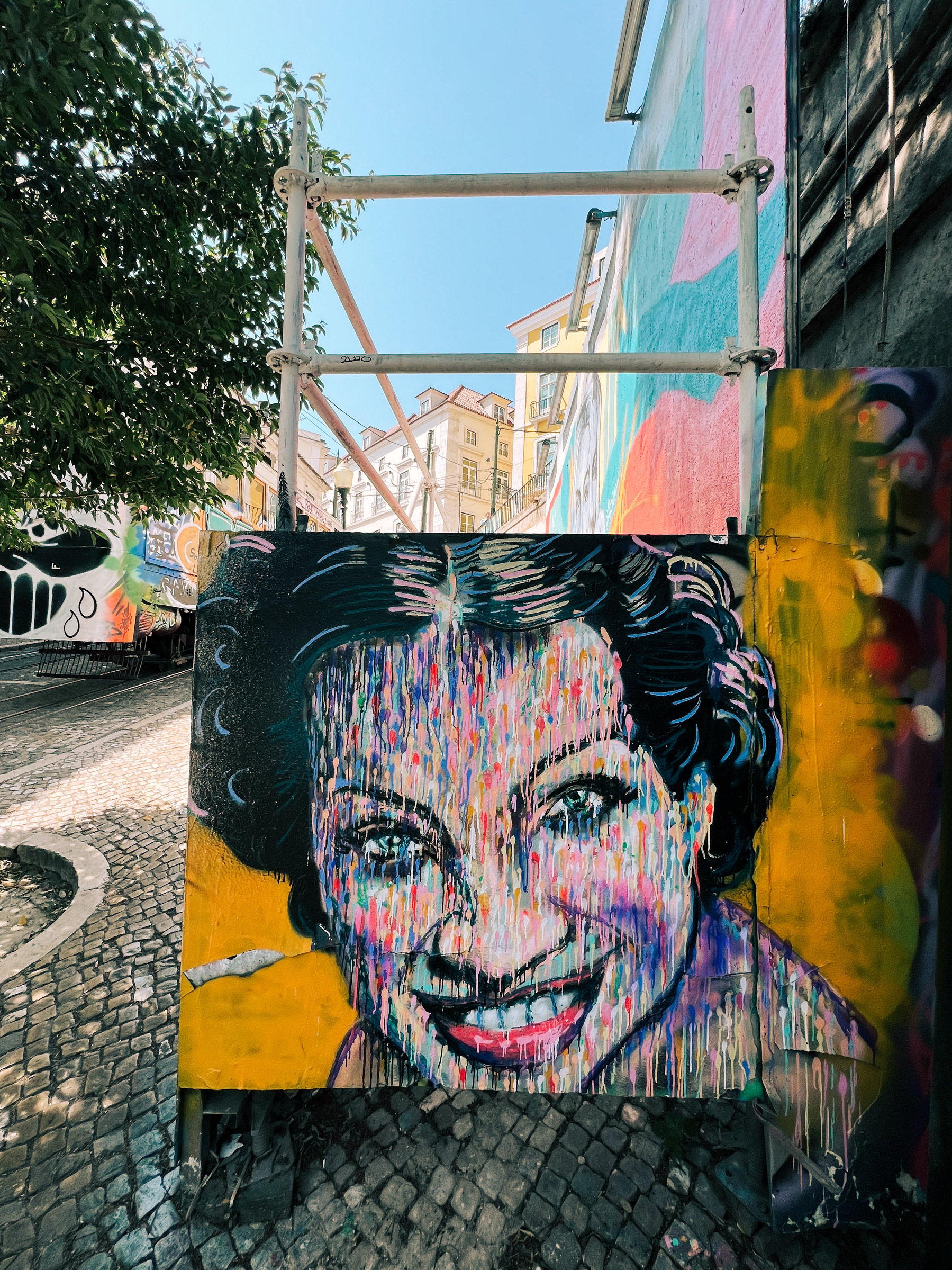 A woman’s face is graffitied on a wall. 