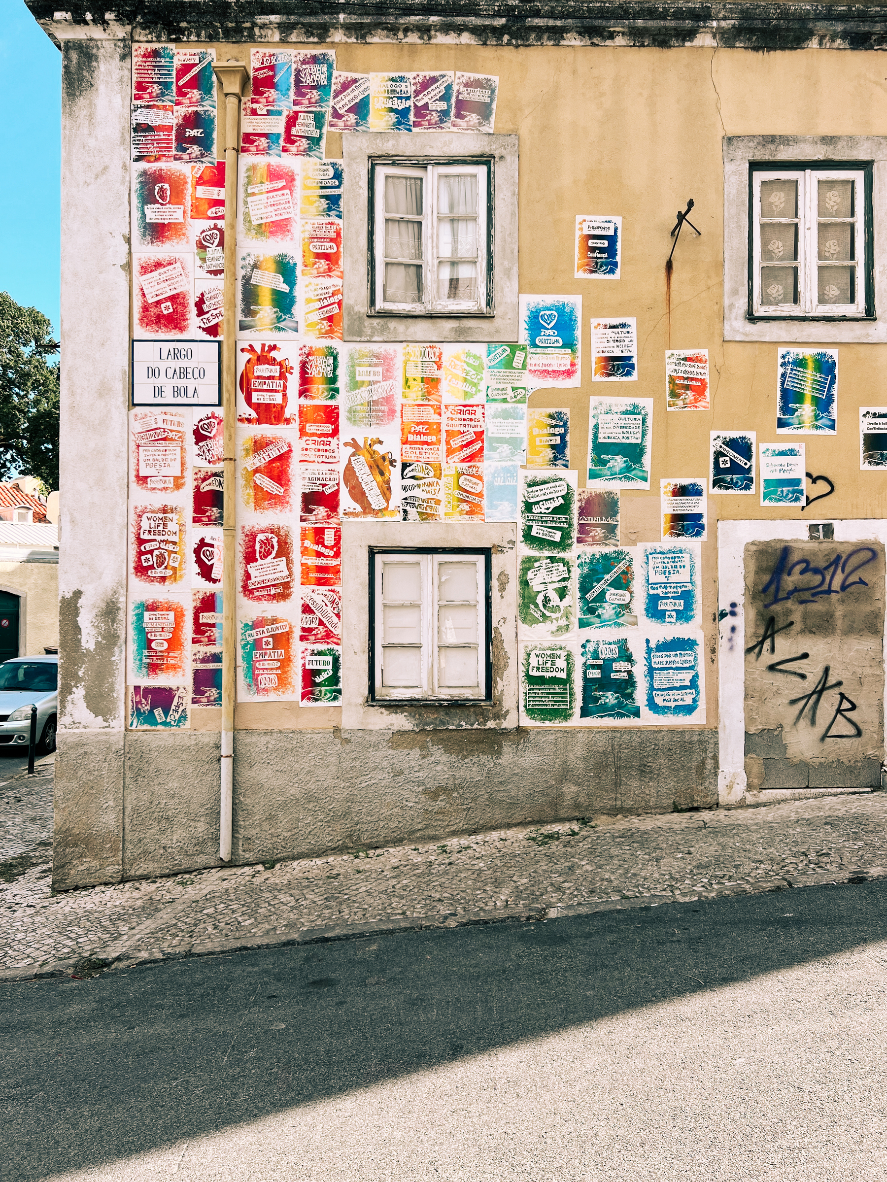 A house’s facade, covered with a4 sized colourful paintings.