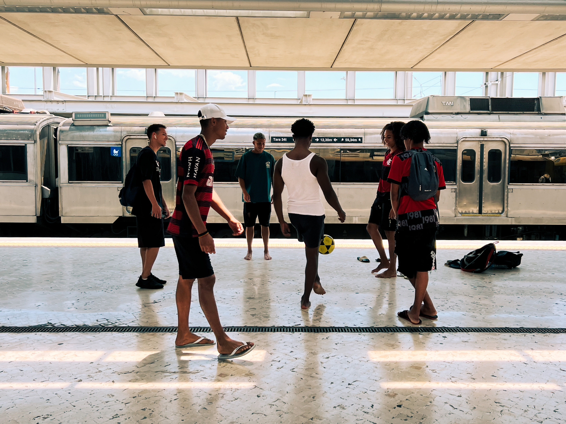 Kids playing football in the train station. 