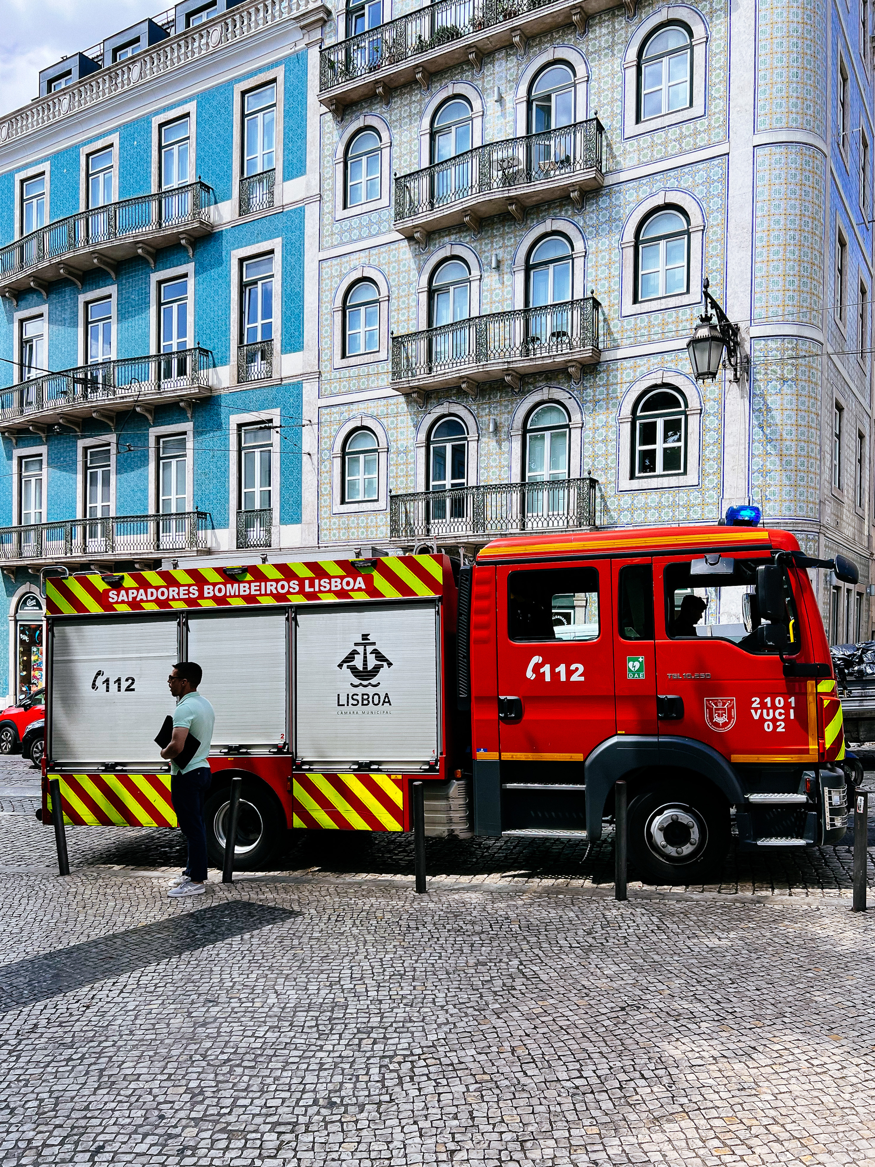 a firetruck parked in front of a classic Lisbon tile-covered building