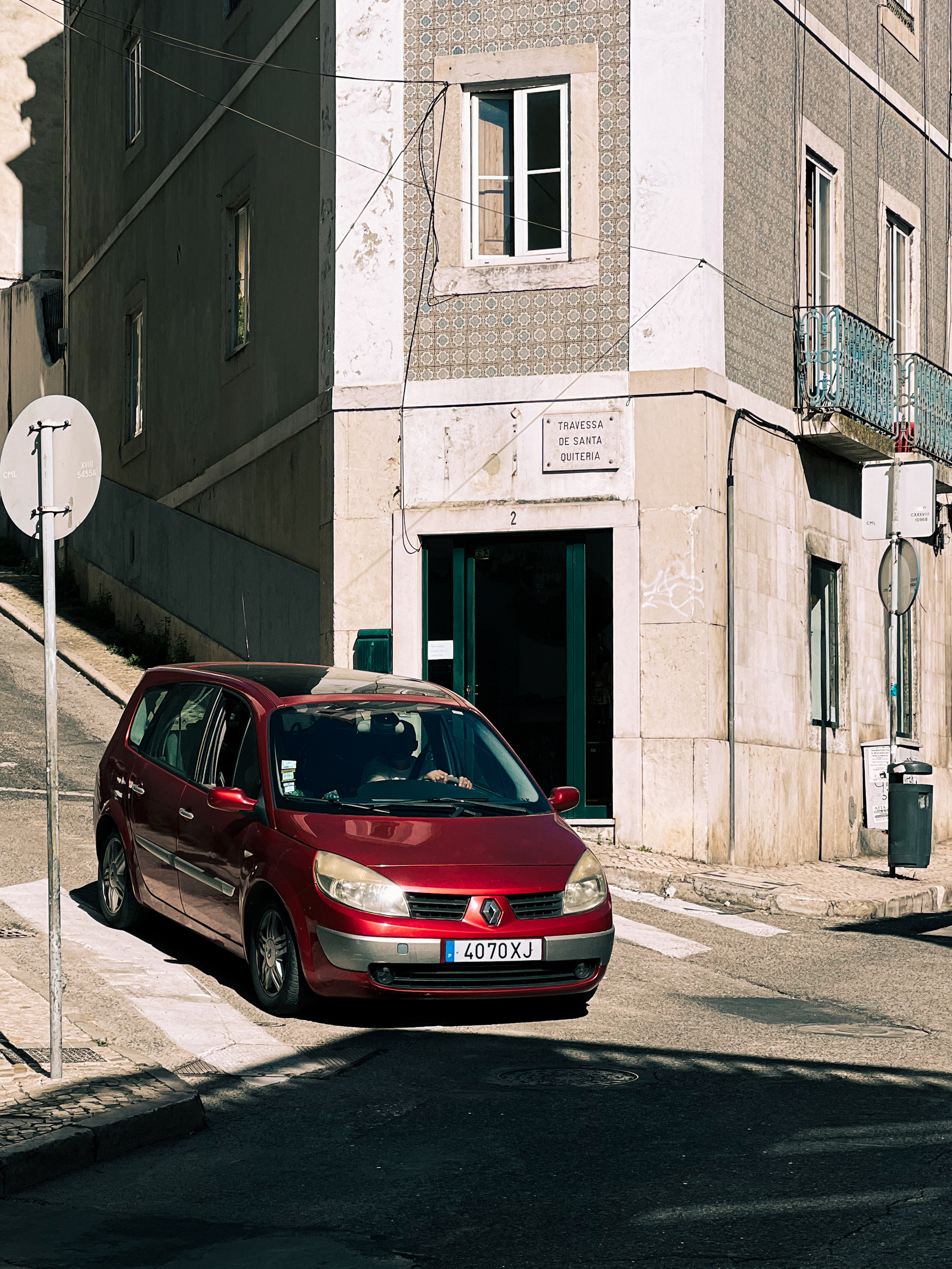 A red car on a street corner. 