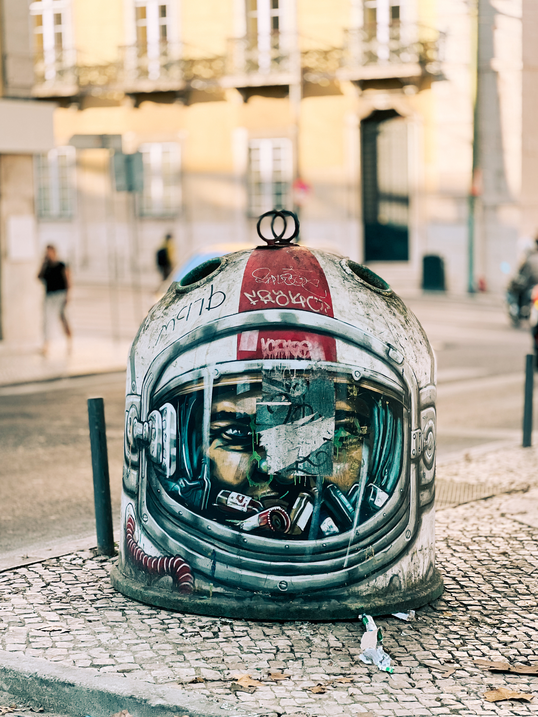 Bottle recycling bin painted as if it’s a helmet. 