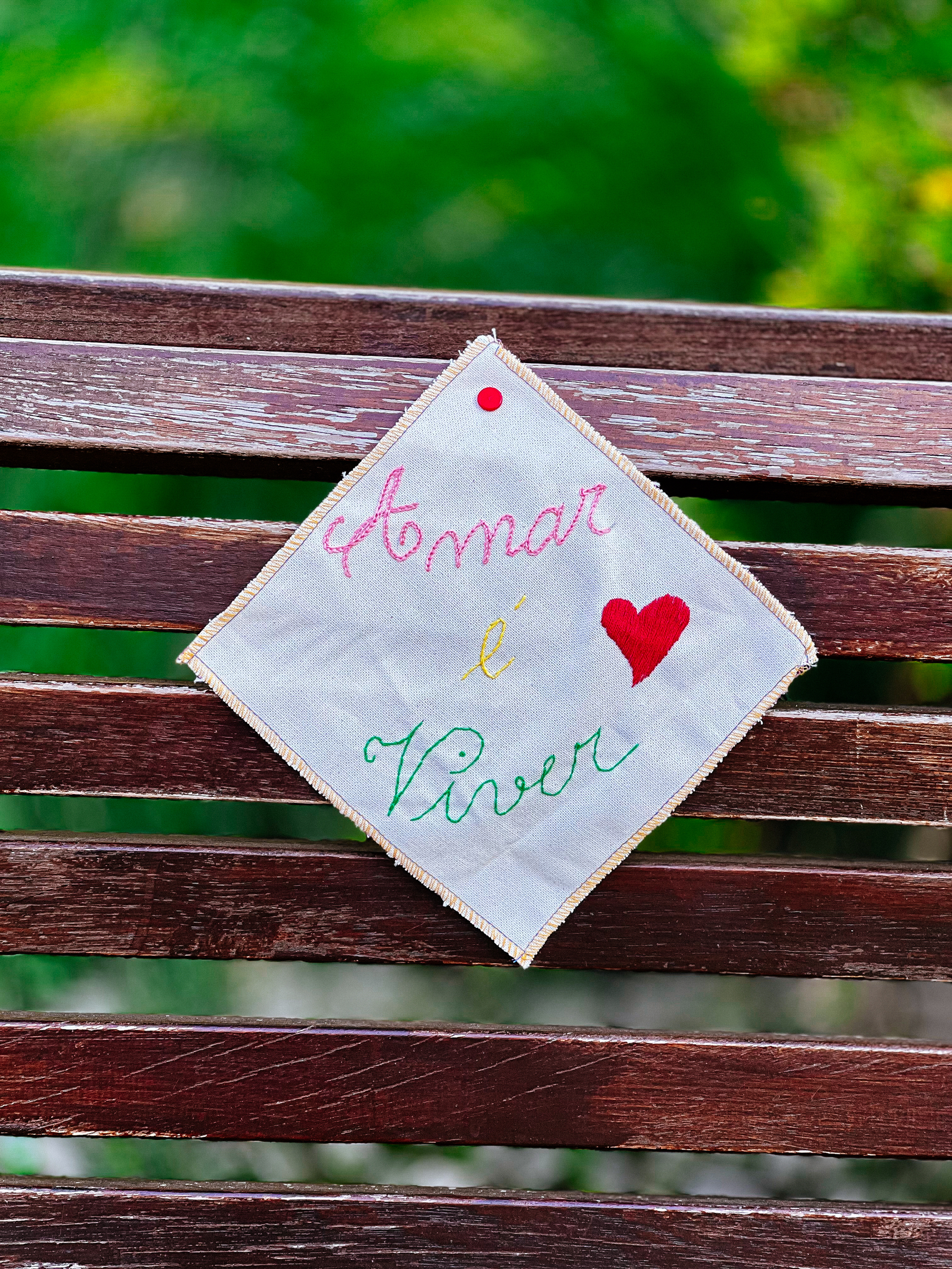 &ldquo;To Love is To Live&rdquo;, embroidered, stuck to a park bench.