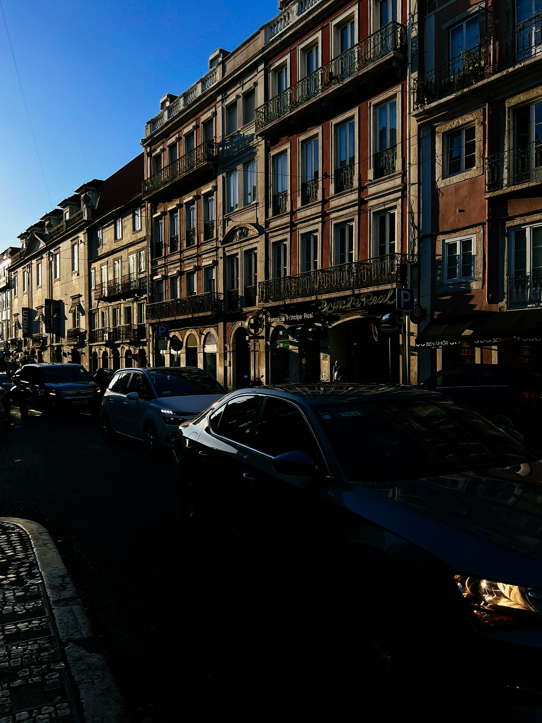 Heavy traffic in downtown Lisbon, a classic building and cars. Dusk.