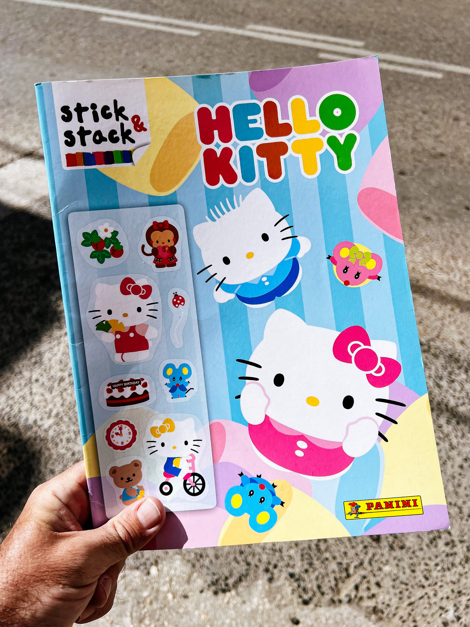A magazine with Hello Kitty is seen on a man’s hand. 