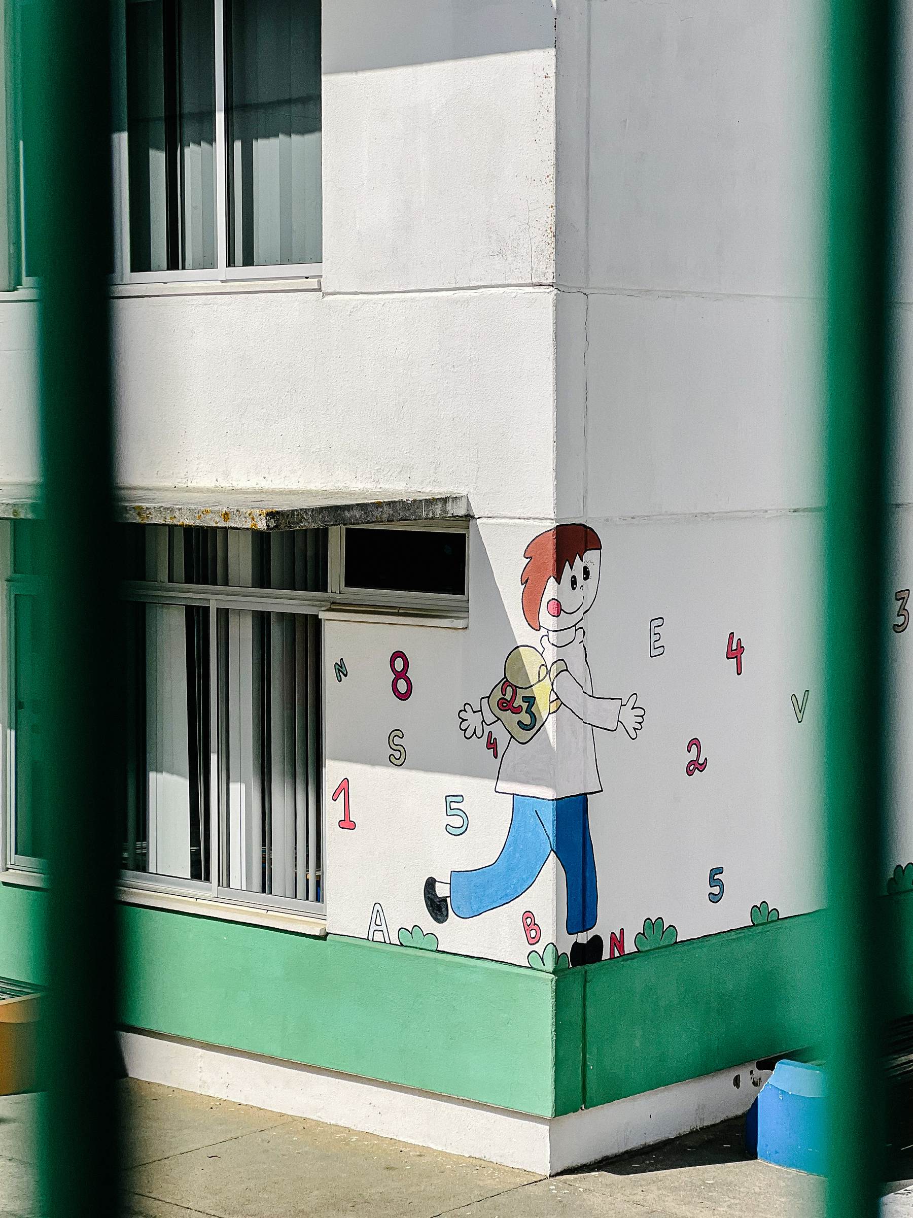 A drawing of a kid on a school wall. 