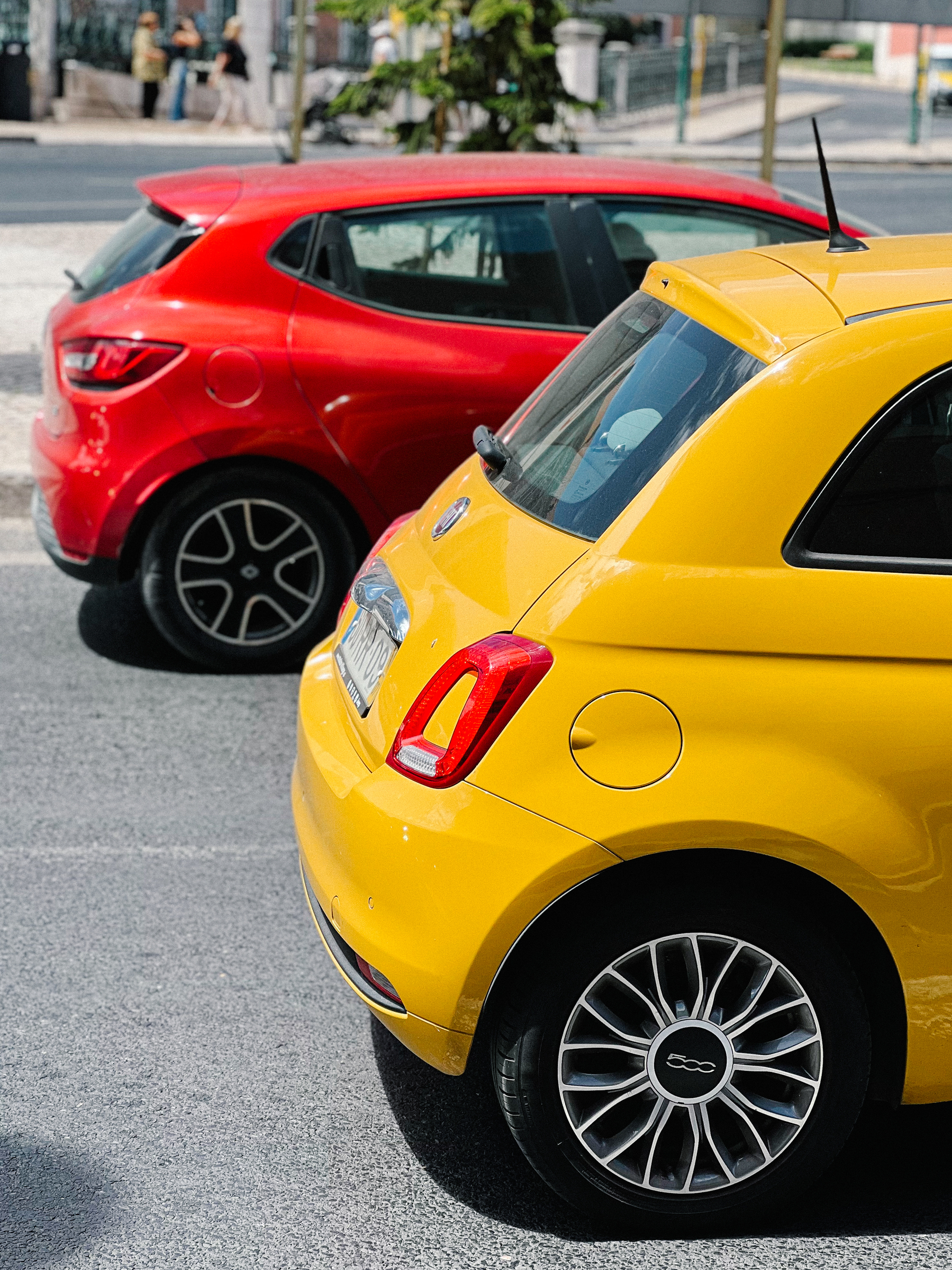 Two cars, one is yellow, the other red.