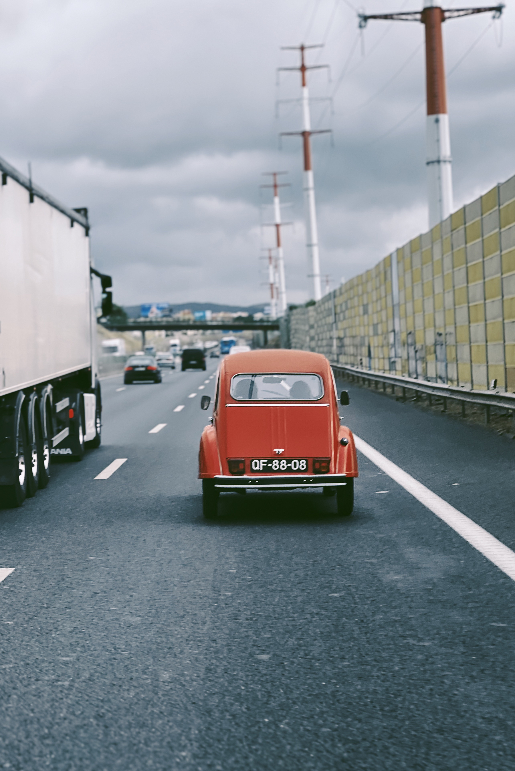 A red 2CV driving on the highway…