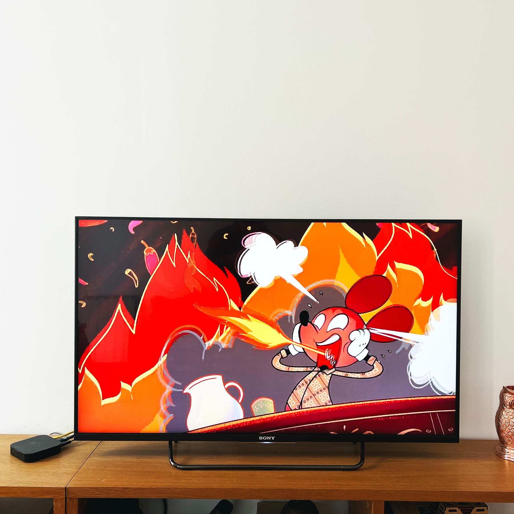 a tv showing Mickey Mouse on fire because he ate very spicy food