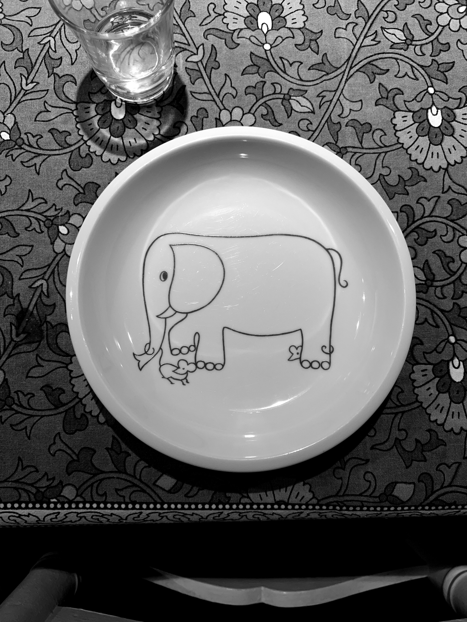 Black and white photo of drawing of an elephant and some mice in a plate. 