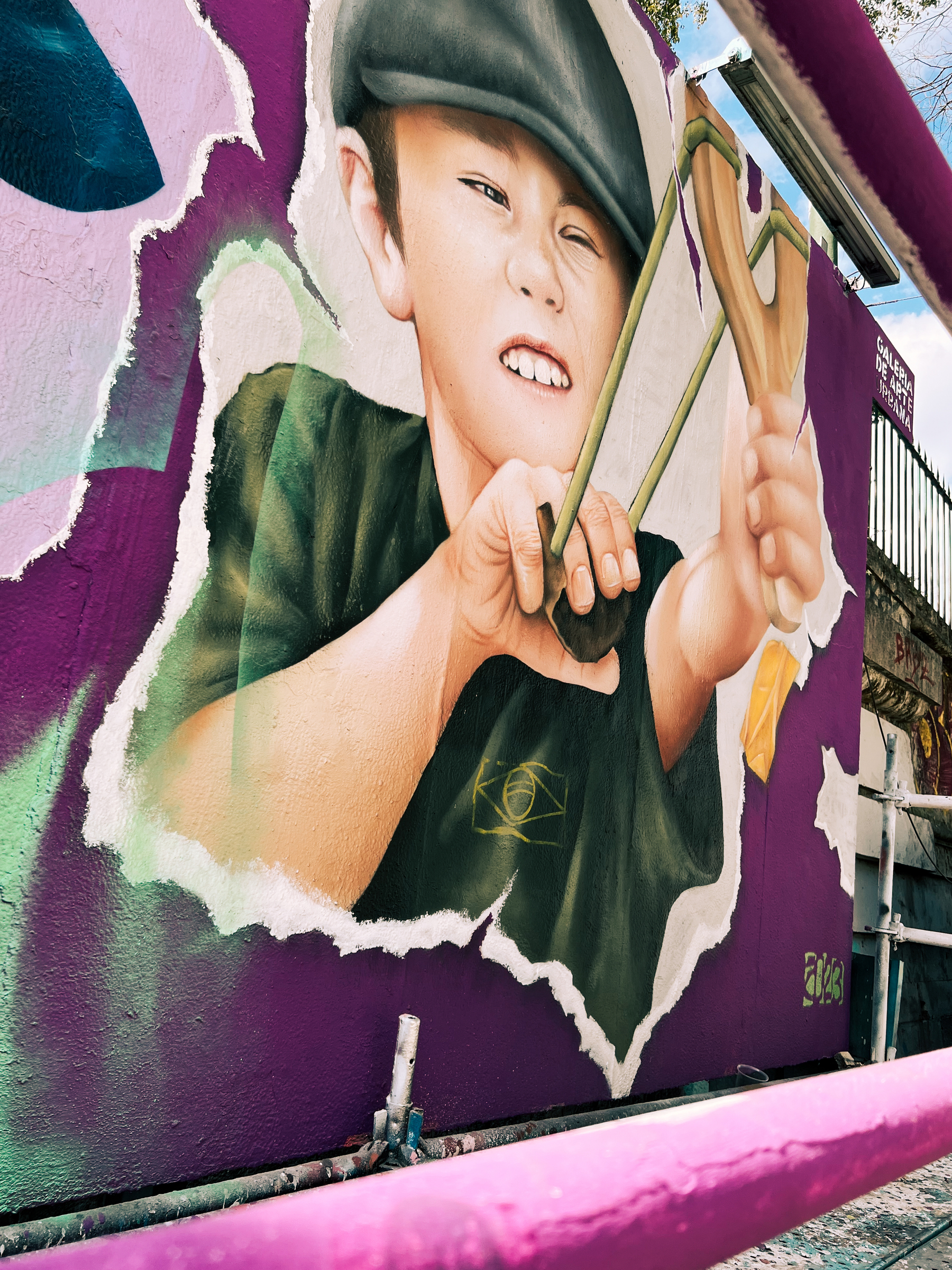 Graffiti of a kid holding a slingshot. 