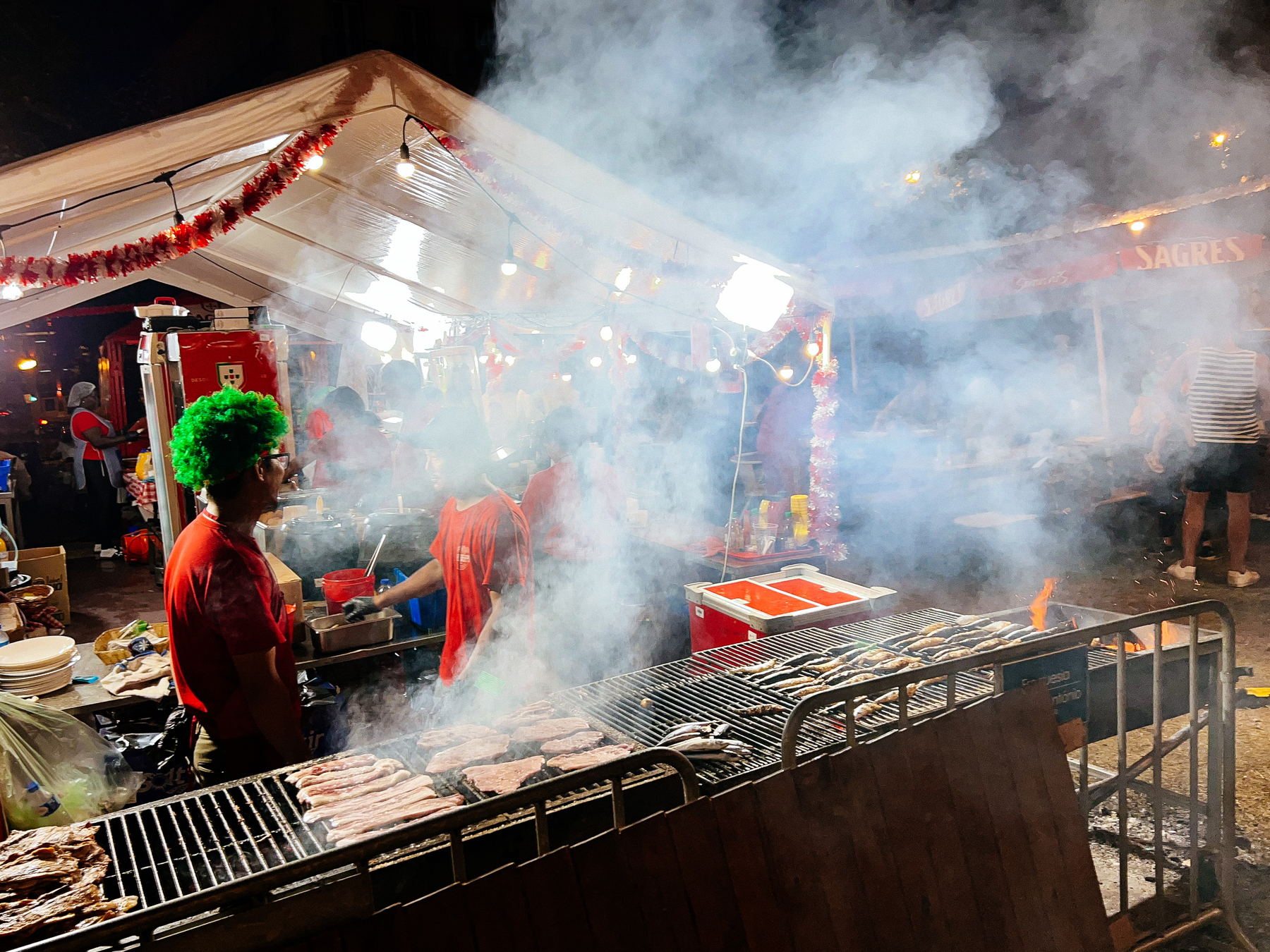 Smoke coming out of a grill. A man is wearing a green wig. 