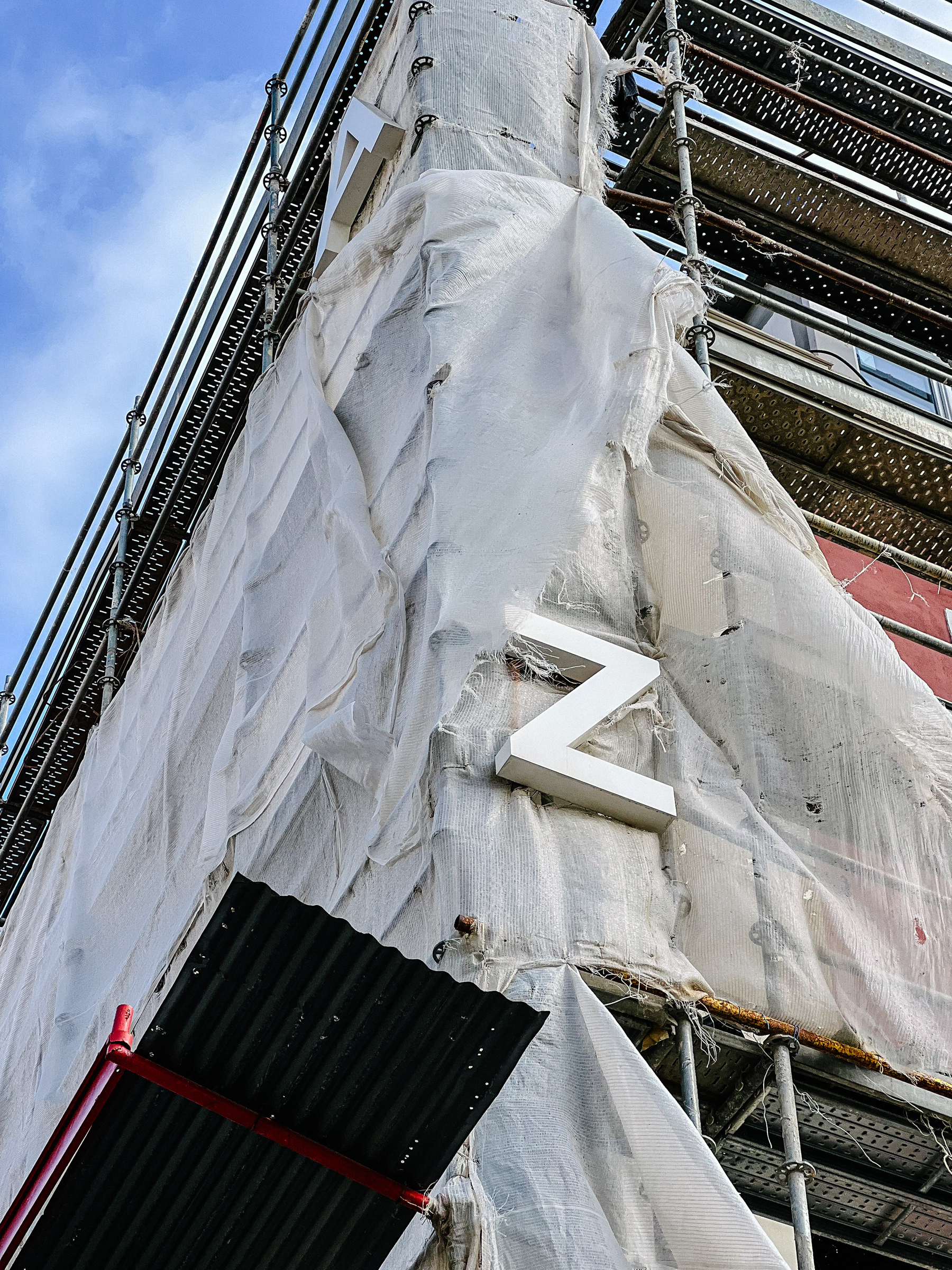 A “Z” on a scaffolding covered building. 